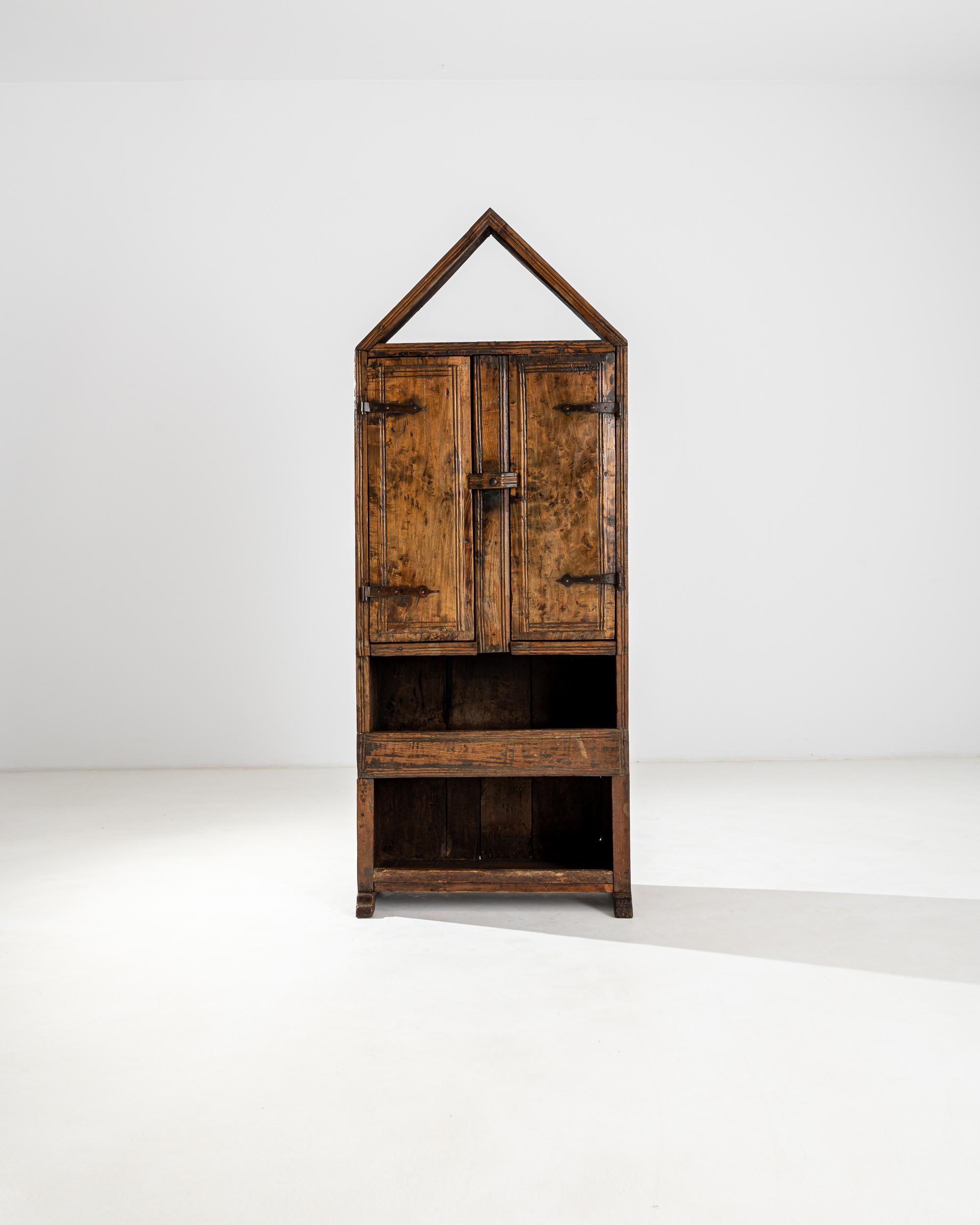 An impressive triangle tops off this 18th century cabinet made in Spain. The construction gives an architectural feel, the gable playfully interacts with the hollow drawers of the lower section elevated on the bracket feet. The upper compartment