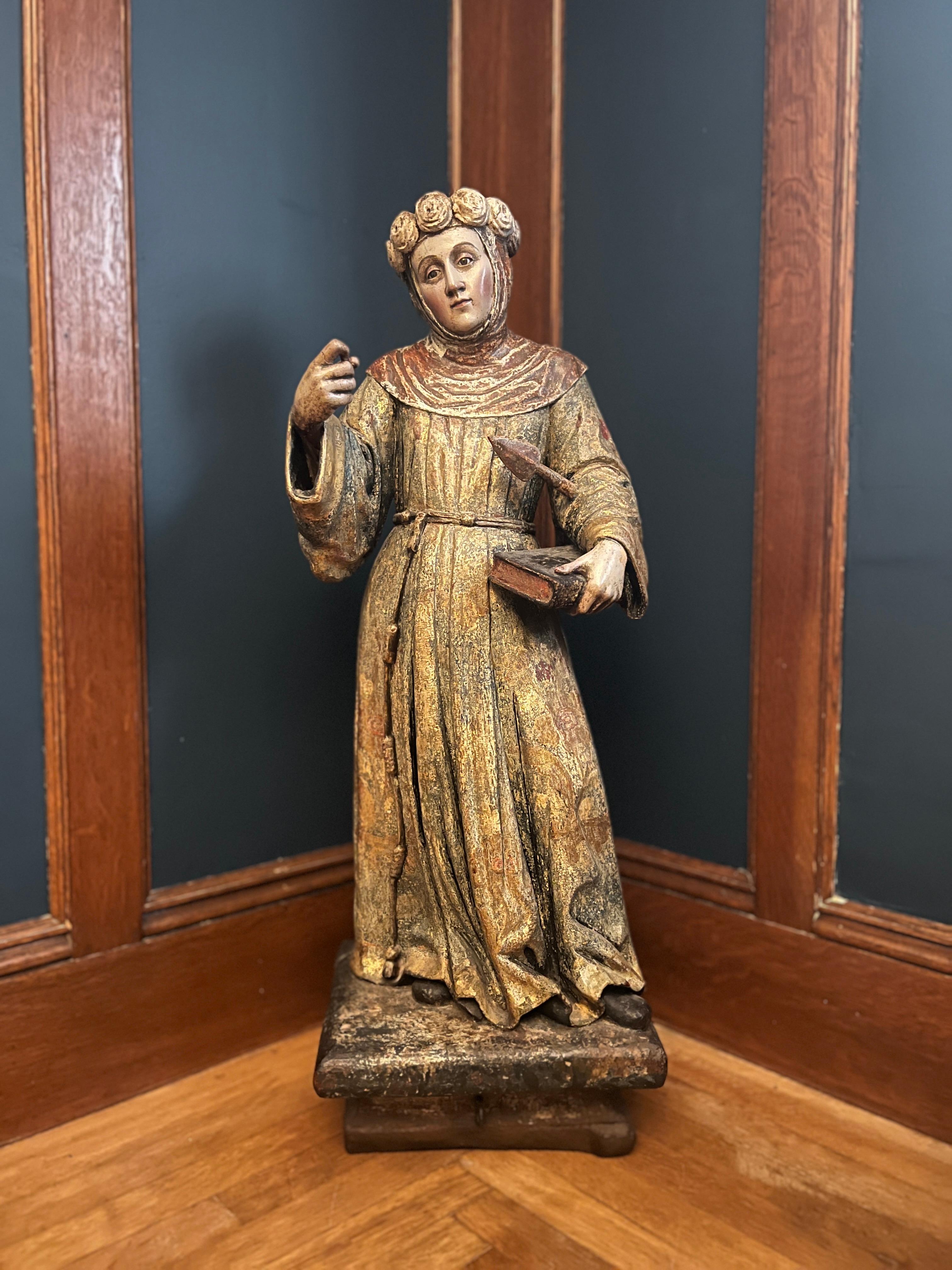 This remarkable 18th-century Spanish School Santos sculpture depicts Saint Ursula, the revered Christian martyr, in a commanding and dignified pose. Standing at an impressive 38.5 inches tall, the polychrome wood sculpture is richly detailed,