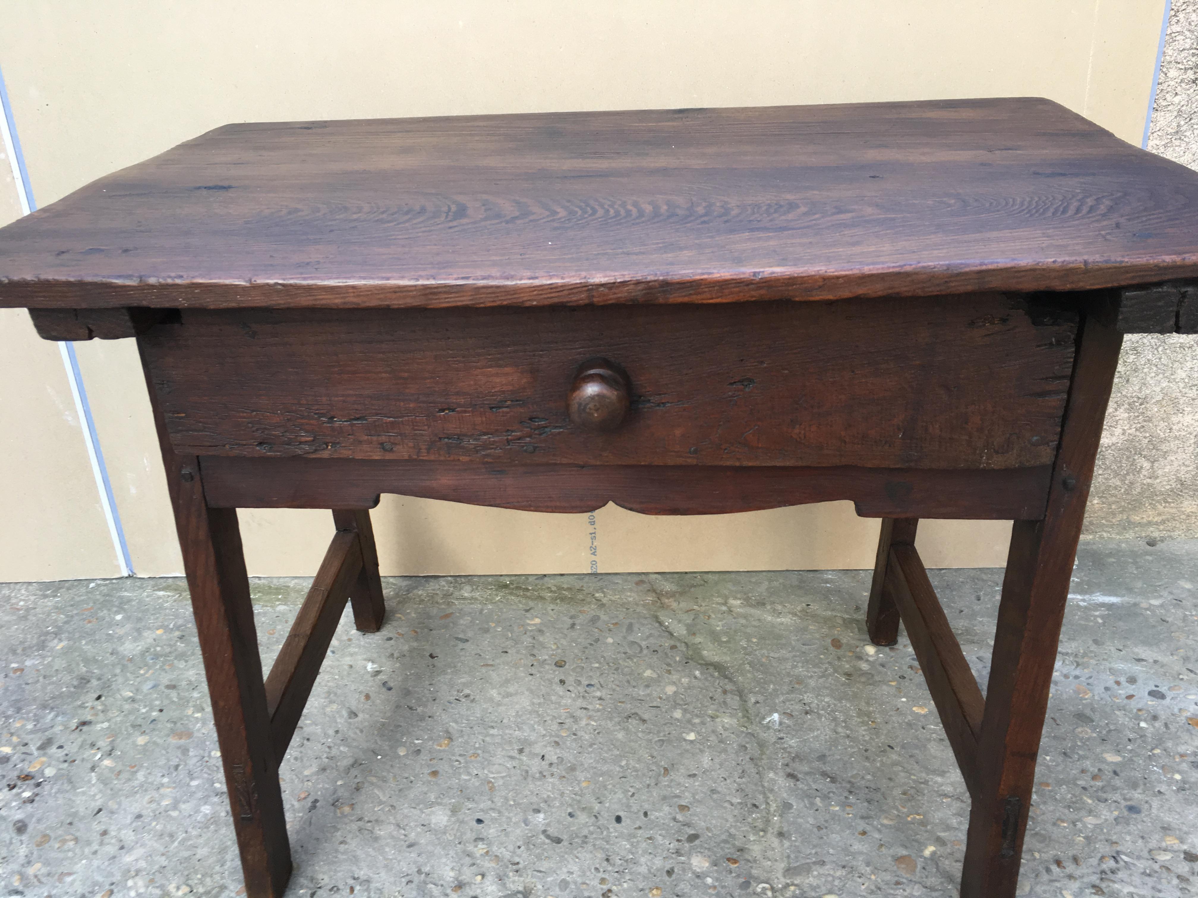 18th century rustic Spanish wooden table with beautiful patina. The table has a large single drawer and is supported on four square legs joined by cross stretchers. 

This table will enhance any rustic themed setting. 