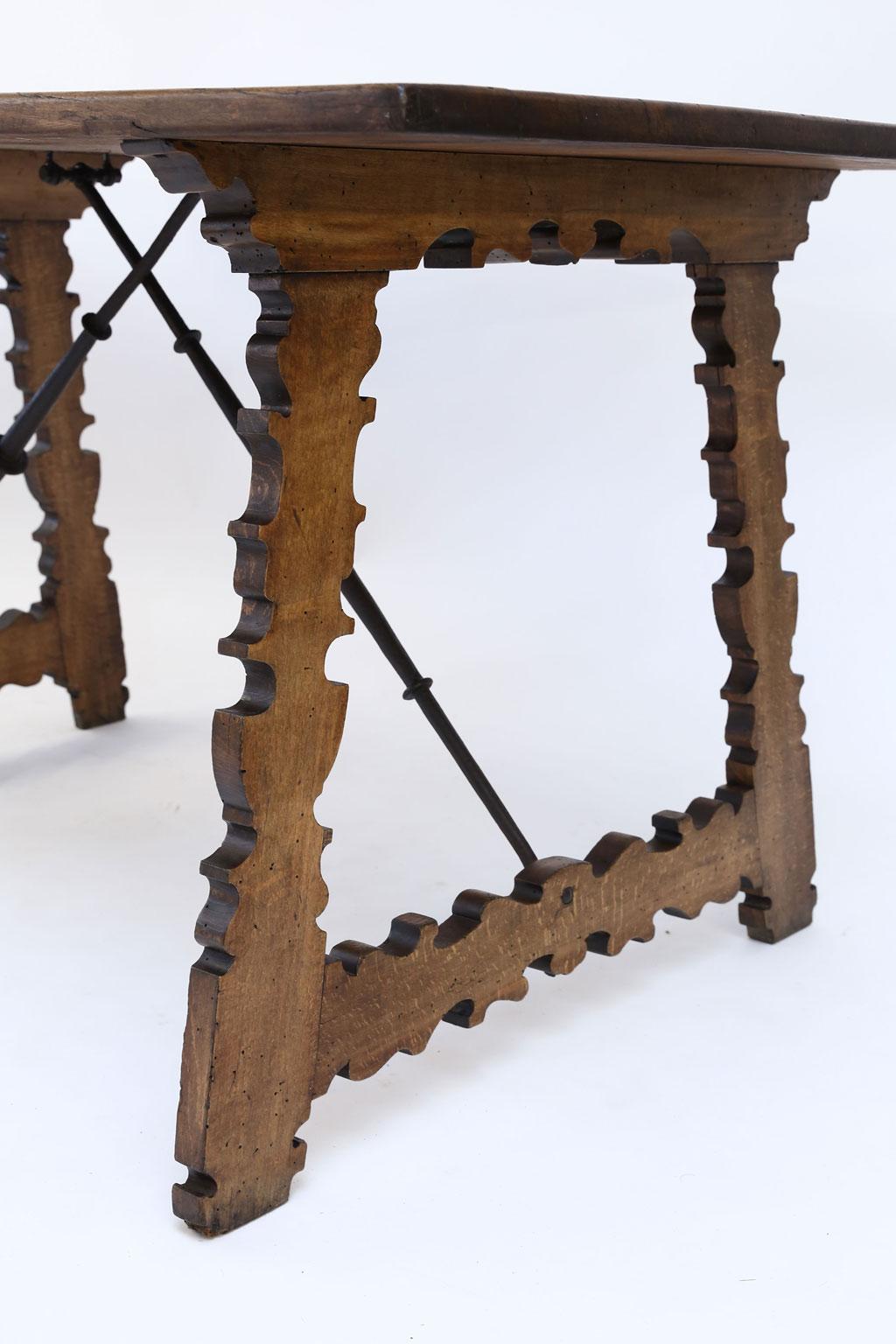 18th century Spanish table, Swietenia mahogany top (Cuban mahogany) raised upon thick hand carved quarter-sawn shaped legs. Nice forged iron under-strapping trestle support. Dates to late 18th century.