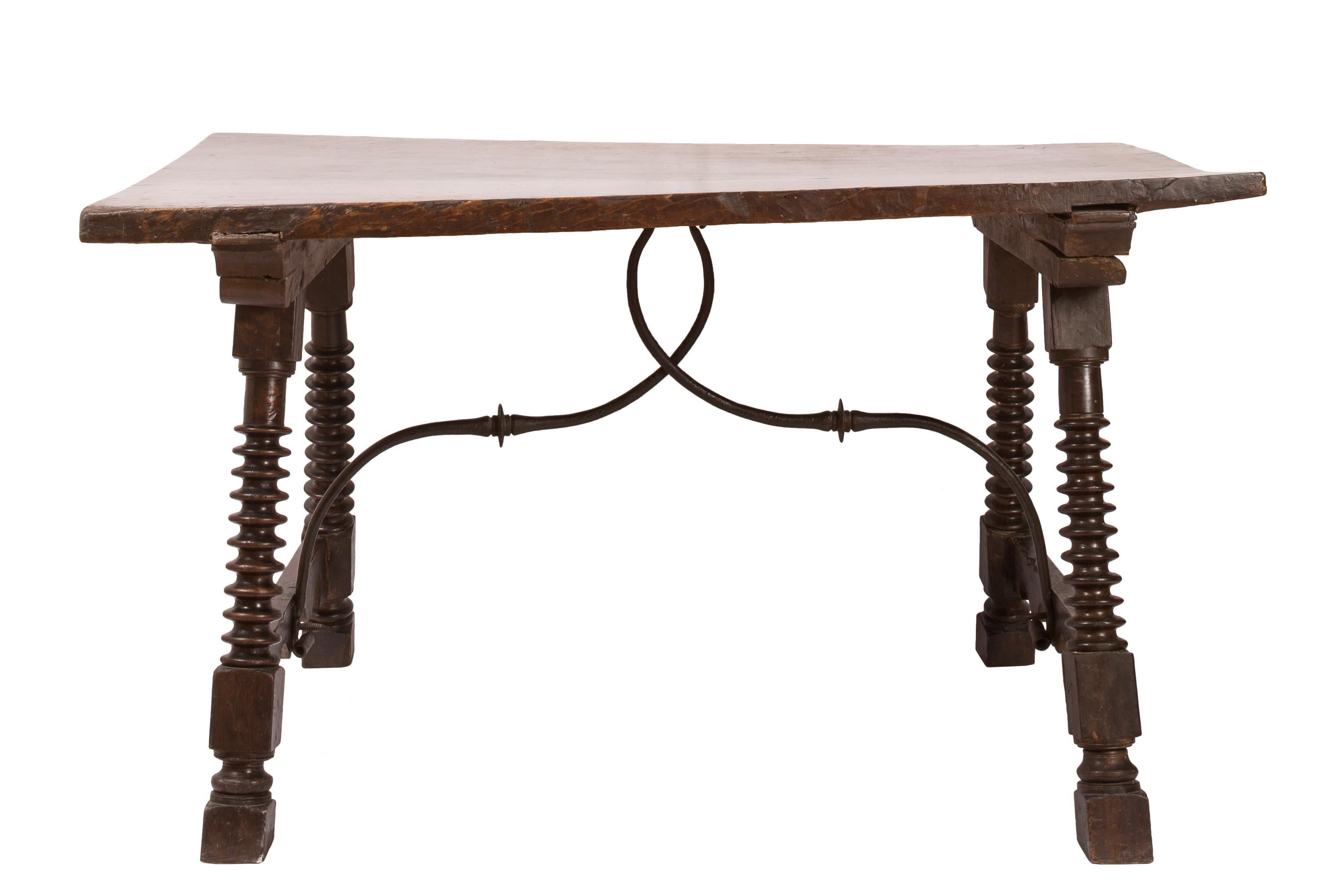 The tabletop of this 18th century Spanish table is one single wide plank, which over the years has warped slightly, adding an attractive twist to the surface and creating a piece of furniture with unique character. The deeply-coved spool turned leg