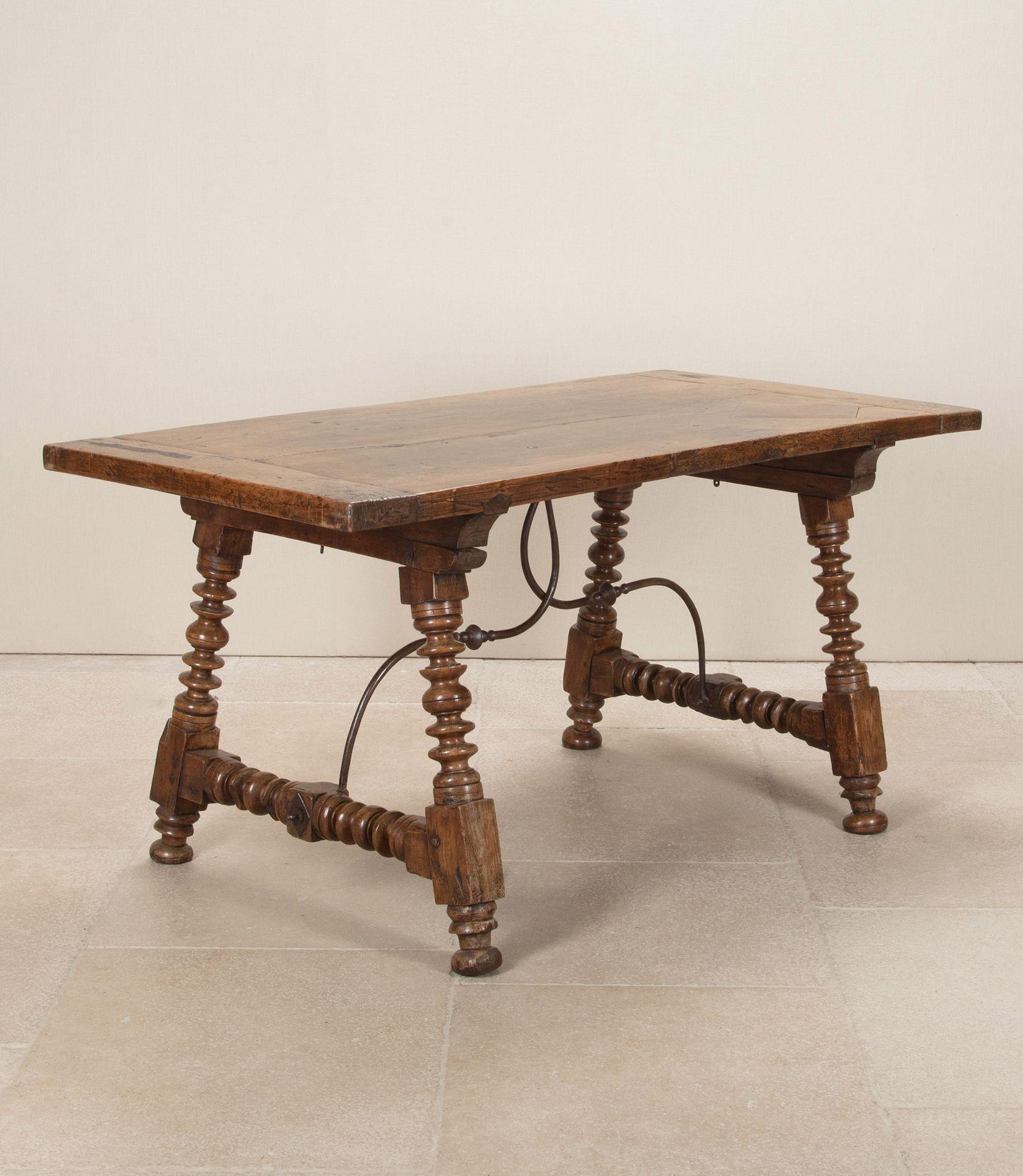 18th Century Spanish walnut centre table. With elegant bobbin or discus carved legs and hand forged metal stretcher.Beautiful aged patina and good historic repairs to the top.