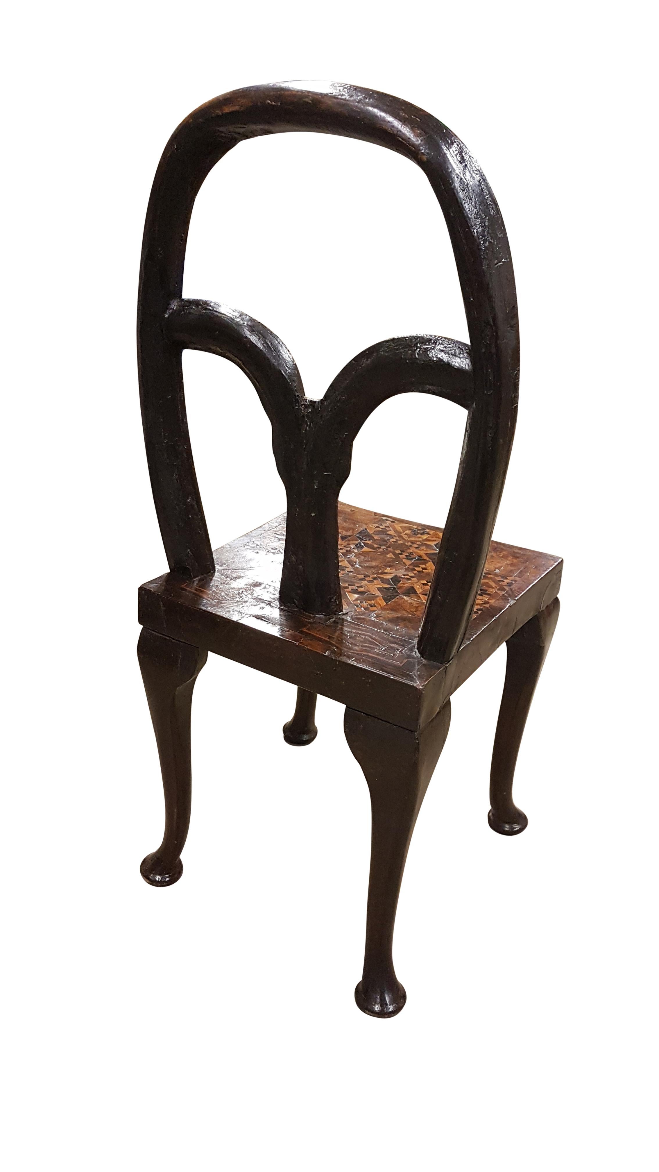 This is an unusual little 18th century and later Spanish walnut chair, the top is veneered and inlaid on the front whilst the back is in branch style. The seat has a beautiful patina to the veneered walnut and inlay, the legs would originally have