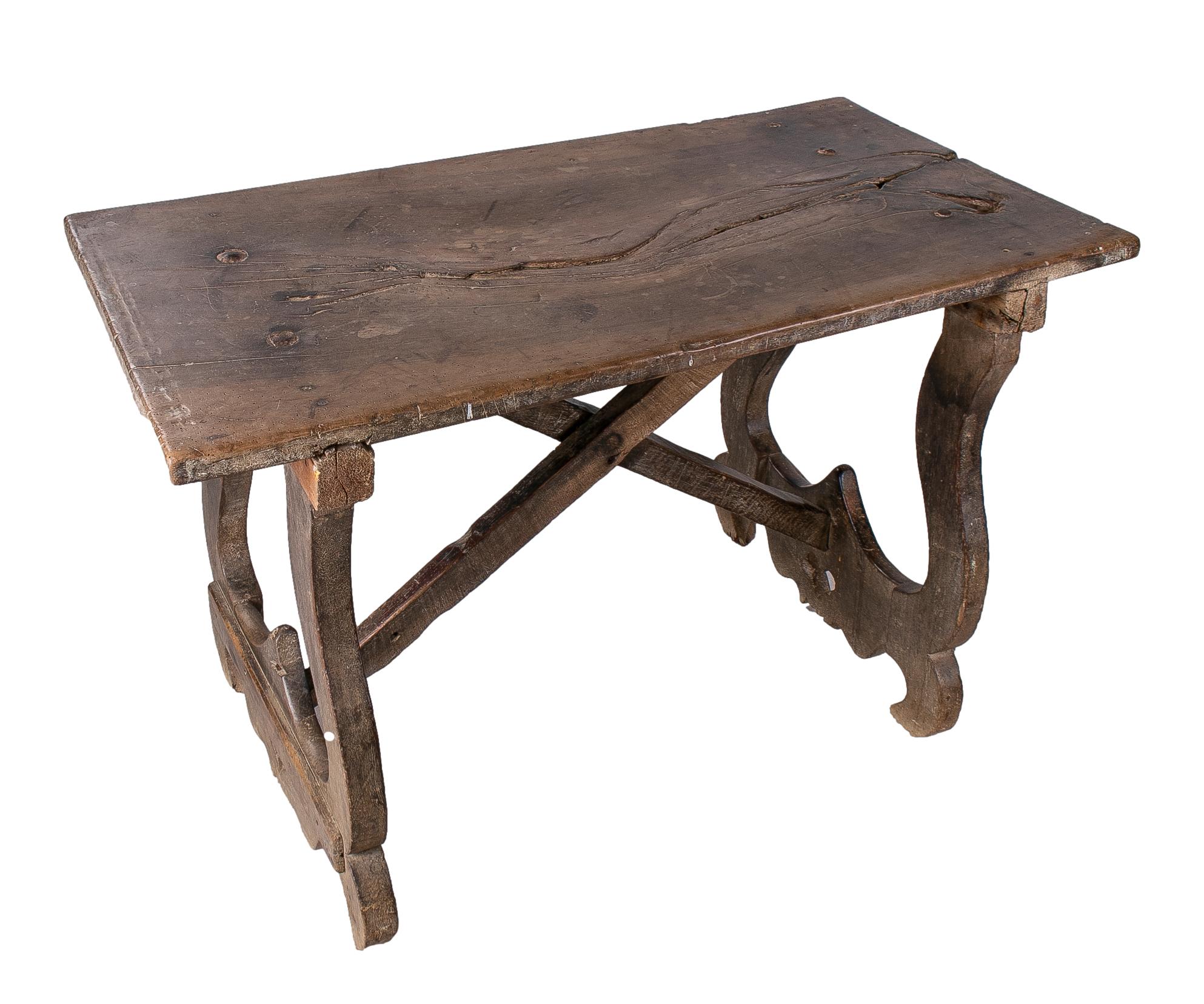 18th century Spanish wooden table with lyre legs and crossbeams.