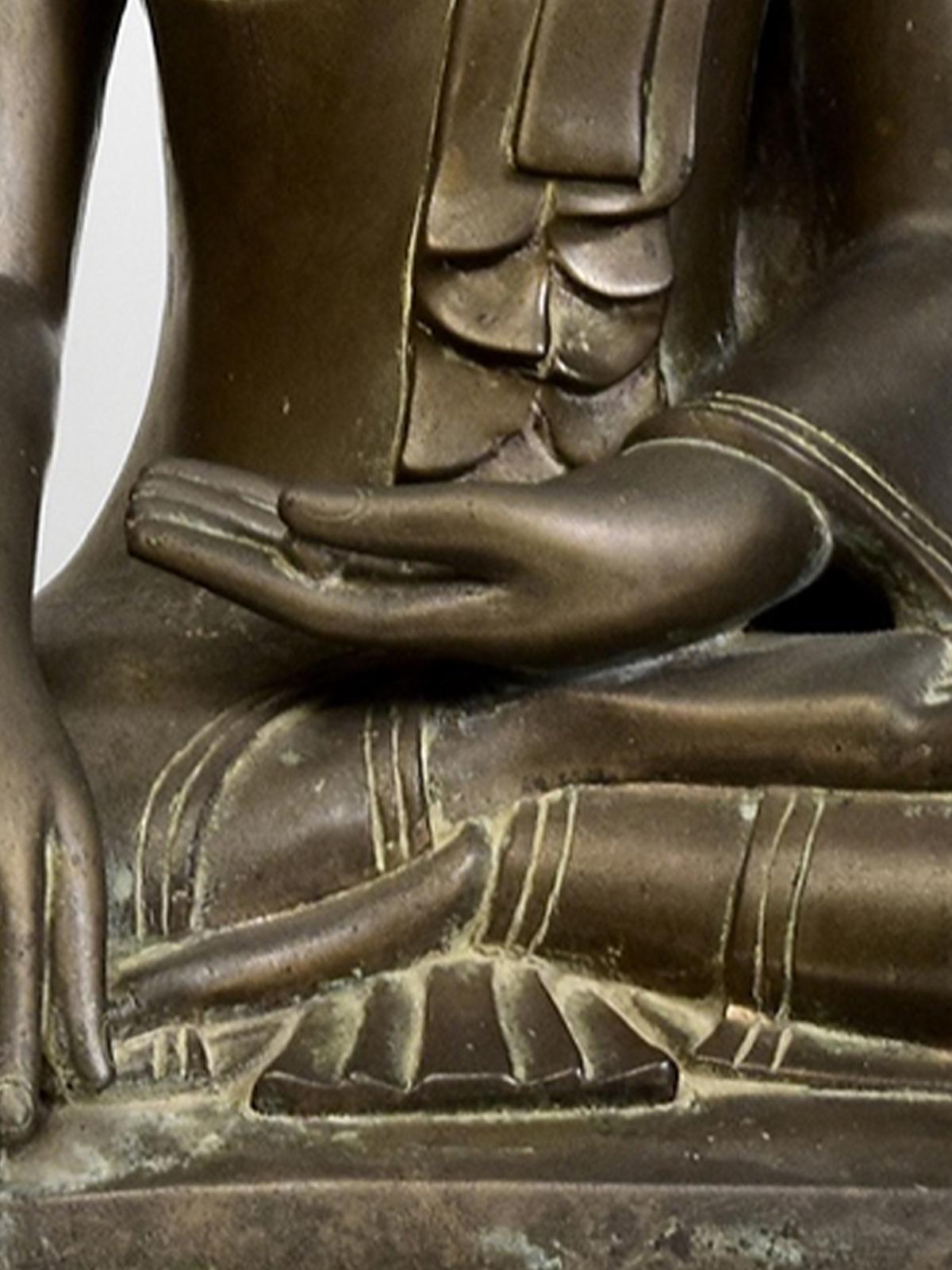 Dieser besondere burmesische Bronze-Buddha aus der Amarapura-Periode ist ein bemerkenswertes und seltenes Stück buddhistischer Kunst, das die Eleganz und spirituelle Tiefe von Burma (Myanmar) im 18. Die aus Bronze gefertigte Statue misst 55,8 cm in