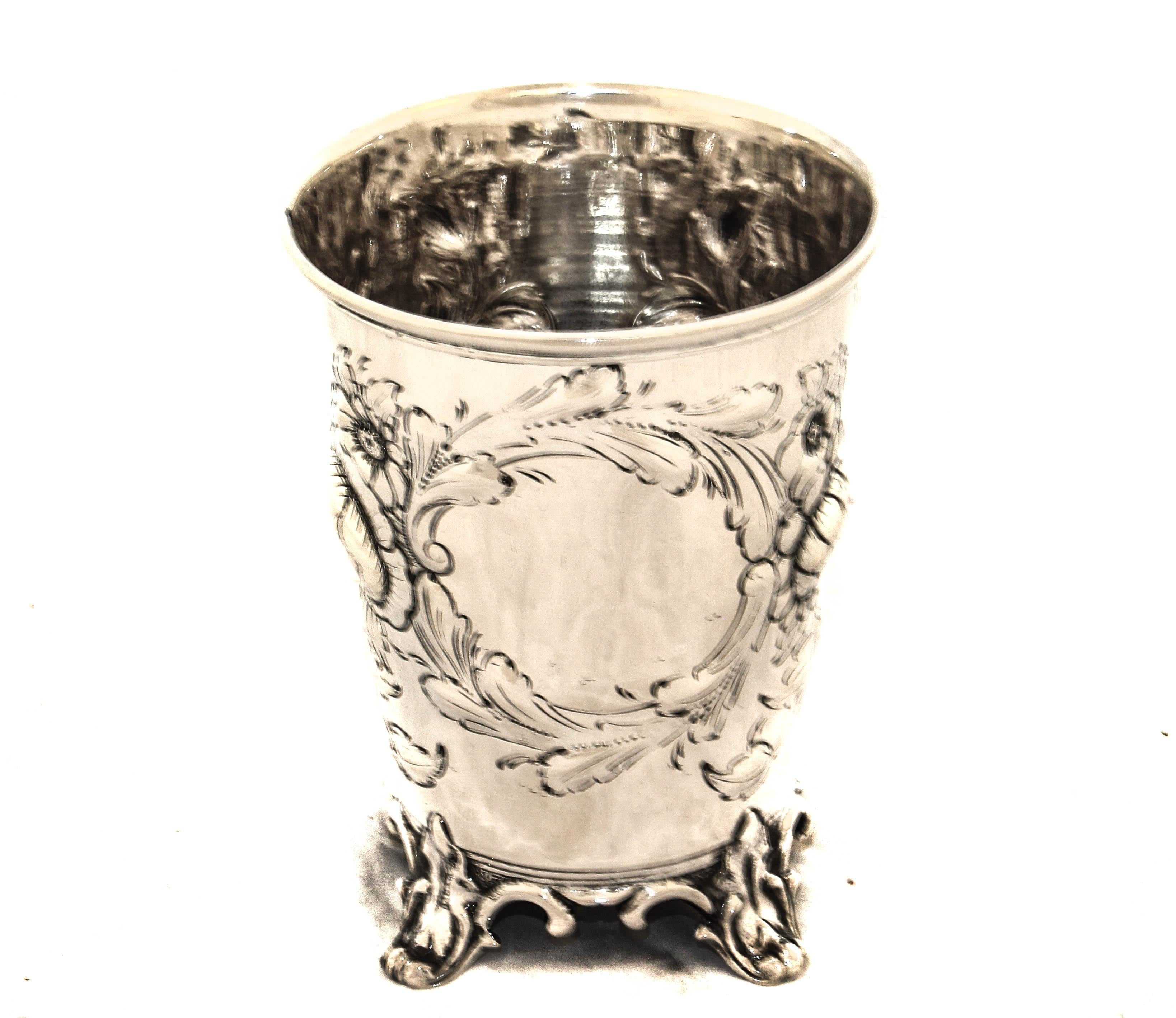 Viene offerto un bicchiere in argento sterling della metà del XVIII secolo di Ball, Black & Company di New York.  Ha un disegno floreale in rilievo che circonda un cartiglio.  Le foglie continuano a percorrere tutto il giro e si incontrano