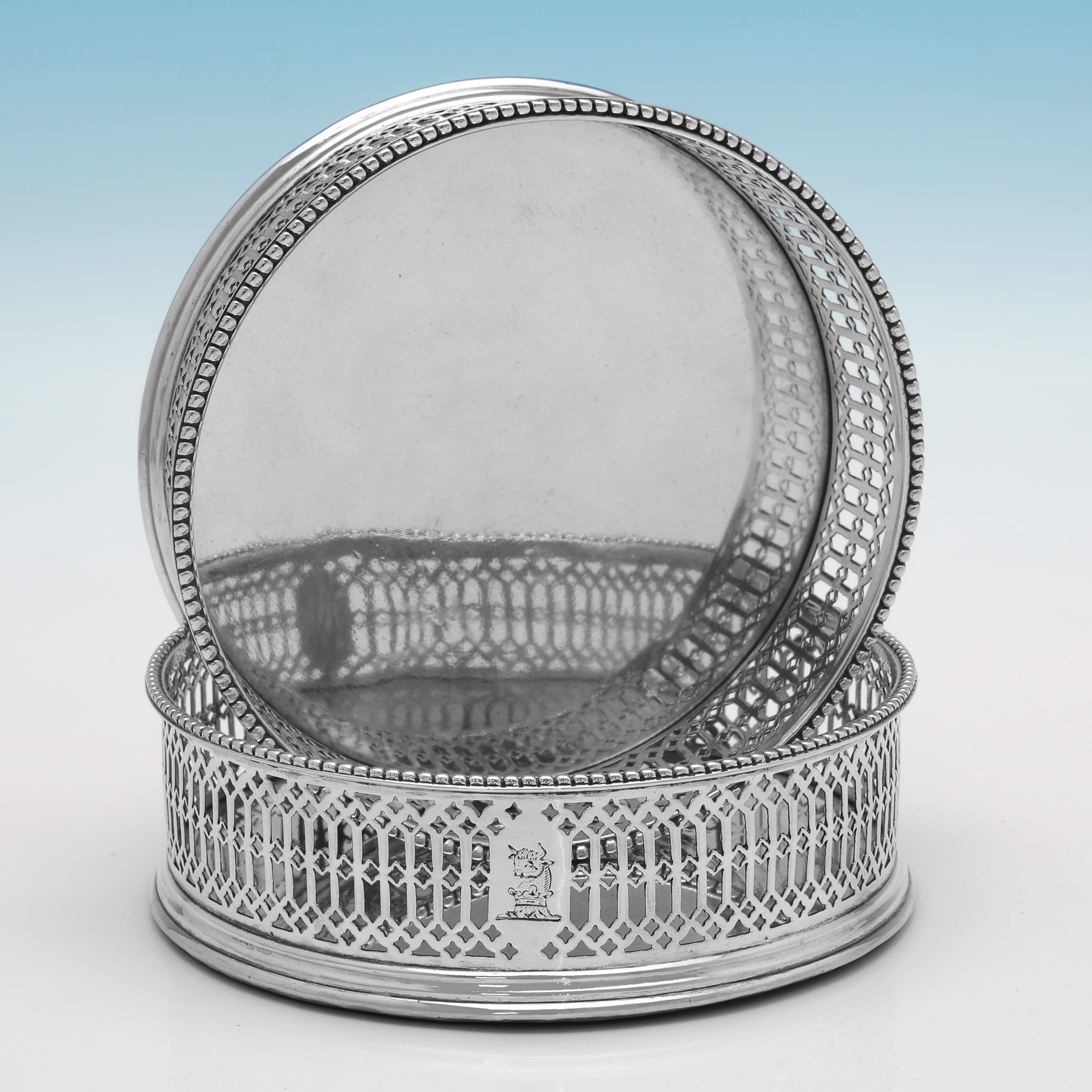 Poinçonnée à Londres en 1773 par Philips Freeman, cette très belle paire de sous-verres anciens en argent sterling d'époque George III présente des côtés percés, des bordures en perles, des inserts en argent sur les bases et des crêtes gravées.