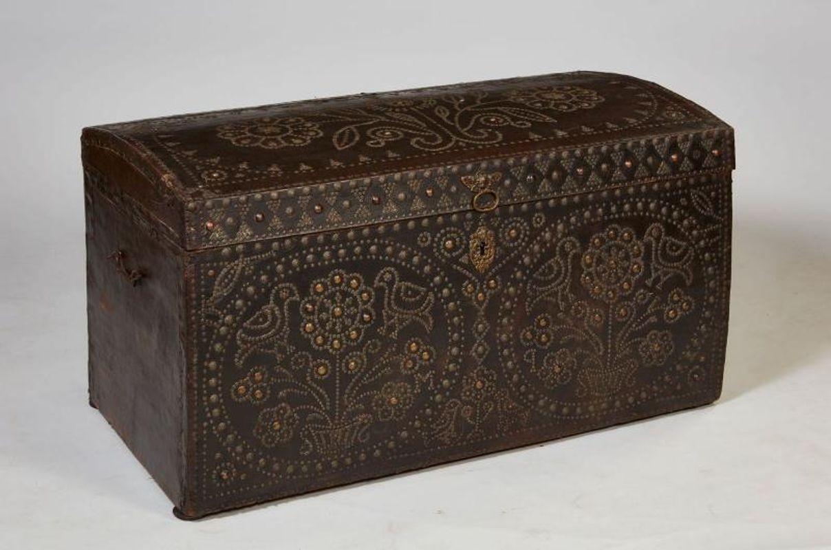 Good early 18th century studded leather travel trunk having slightly domed top having flower motif, the front similarly decorated in both brass and steel studs, the body covered in rich 