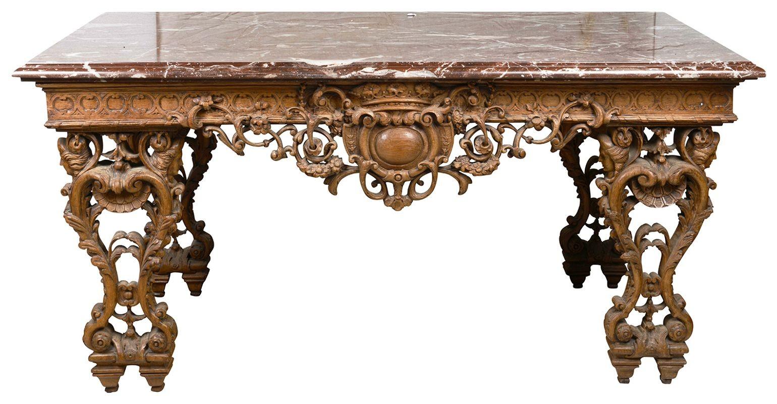 



A wonderful early 19th Century, French carved free standing Oak centre / console table. Having its original Grotto De Belloc marble top. Hand carved roundel, blind fretwork to the frieze, with fan like mounts to the four sides, scrolling foliate