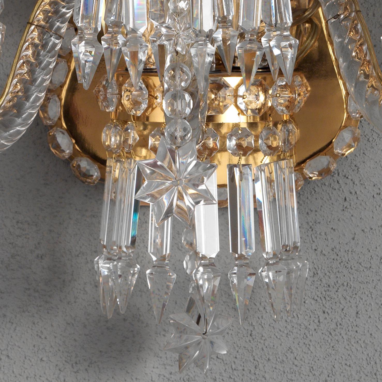 This elegant 18th Century Style Crystal and Blown Glass Wall Sconce by Gherardo Degli Albizzi, in blown glass, is made in transparent color with gilded backplate. This sconce is composed by a single branch layer. At the top there is a crystal