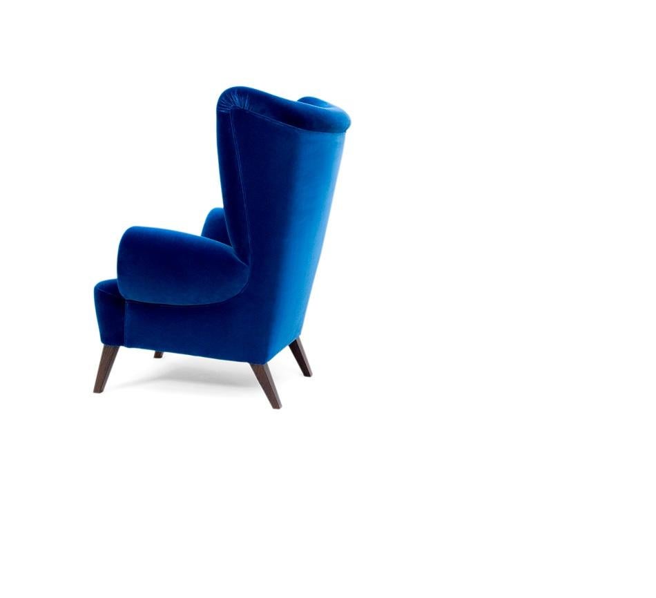 Dieser Sessel ist vom englischen Design des 18. Jahrhunderts inspiriert. Mit seiner weich gepolsterten hohen Rückenlehne und der detaillierten Polsterung schafft er ein Gleichgewicht zwischen Komfort und Stil. Die maßgeschneiderten Proportionen