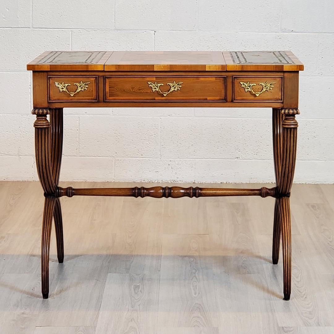 A unique and versatile 18th Century style Games Table in Yew with chess board and backgammon as well as a reversible green leather top.  The embossed leather on the three panels presents a statement of elegance with the less than perfect appearance