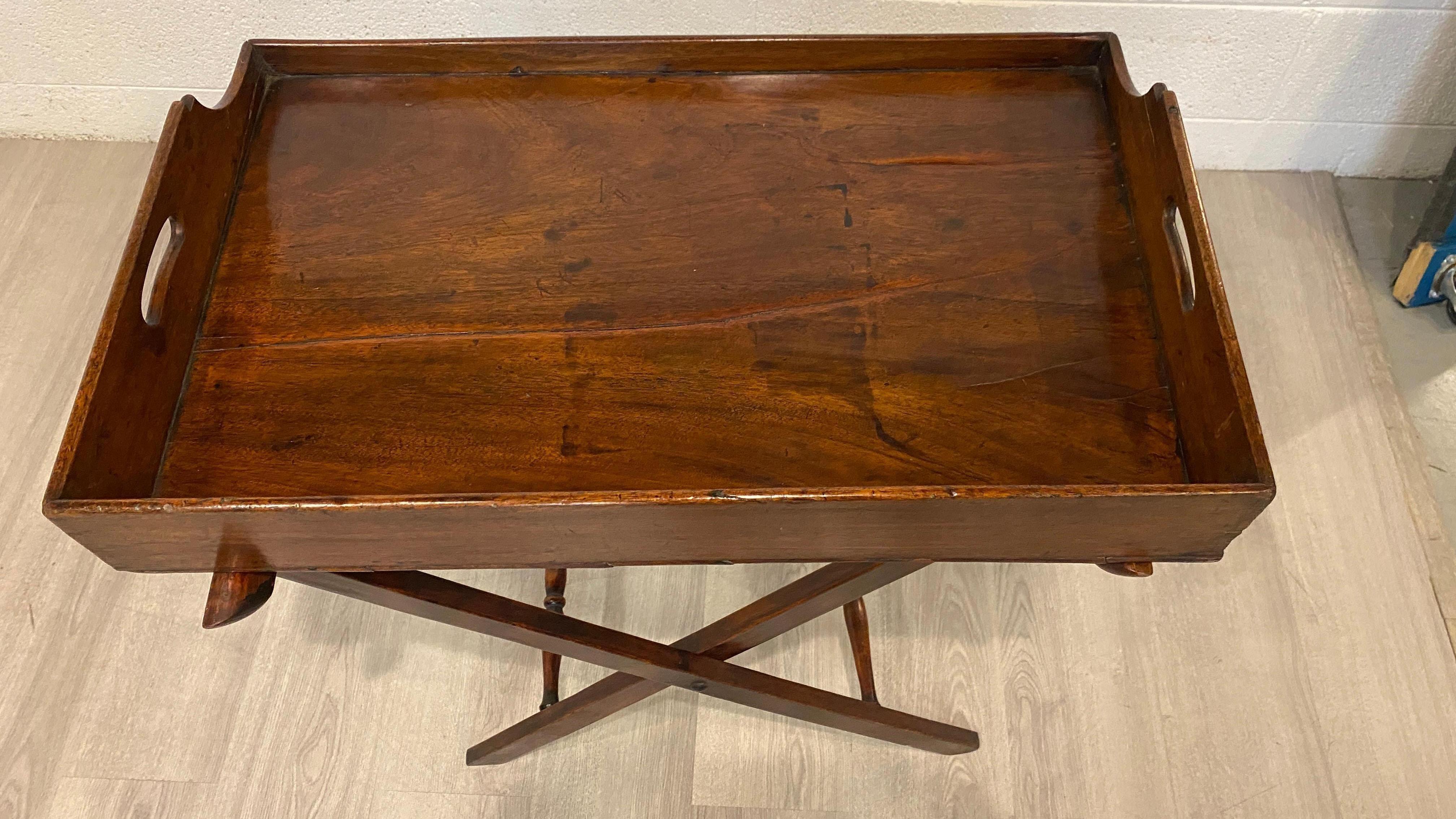 Made not in the last century,  but the century before that one, this butlers tray serving table is a truly wonderful example of understated elegance.
Crafted likely of mahogany in the traditional way with solid structure and the flexibility and