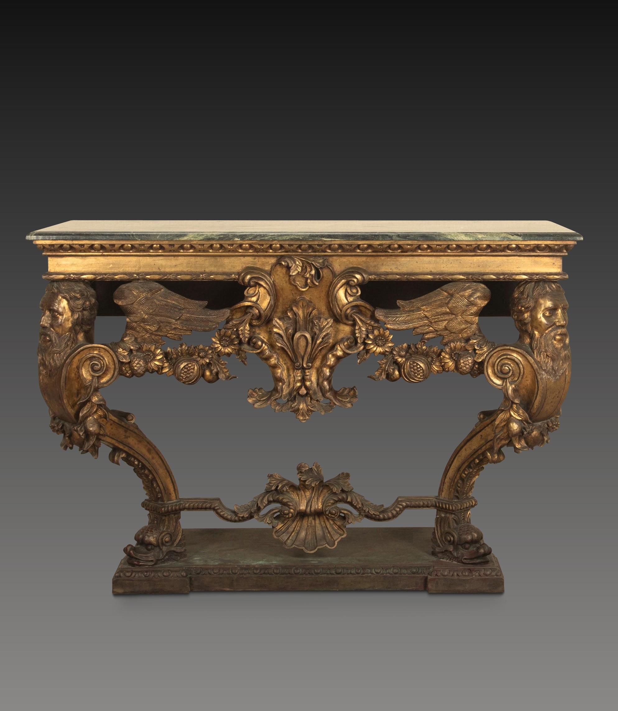 An impressive carved Italian console table in the early 18th century style, the green marble top with moulded edge above a bold carved base, with egg and dart moulded frieze and central cartouche, flanked by fruiting and foliate swags and supported