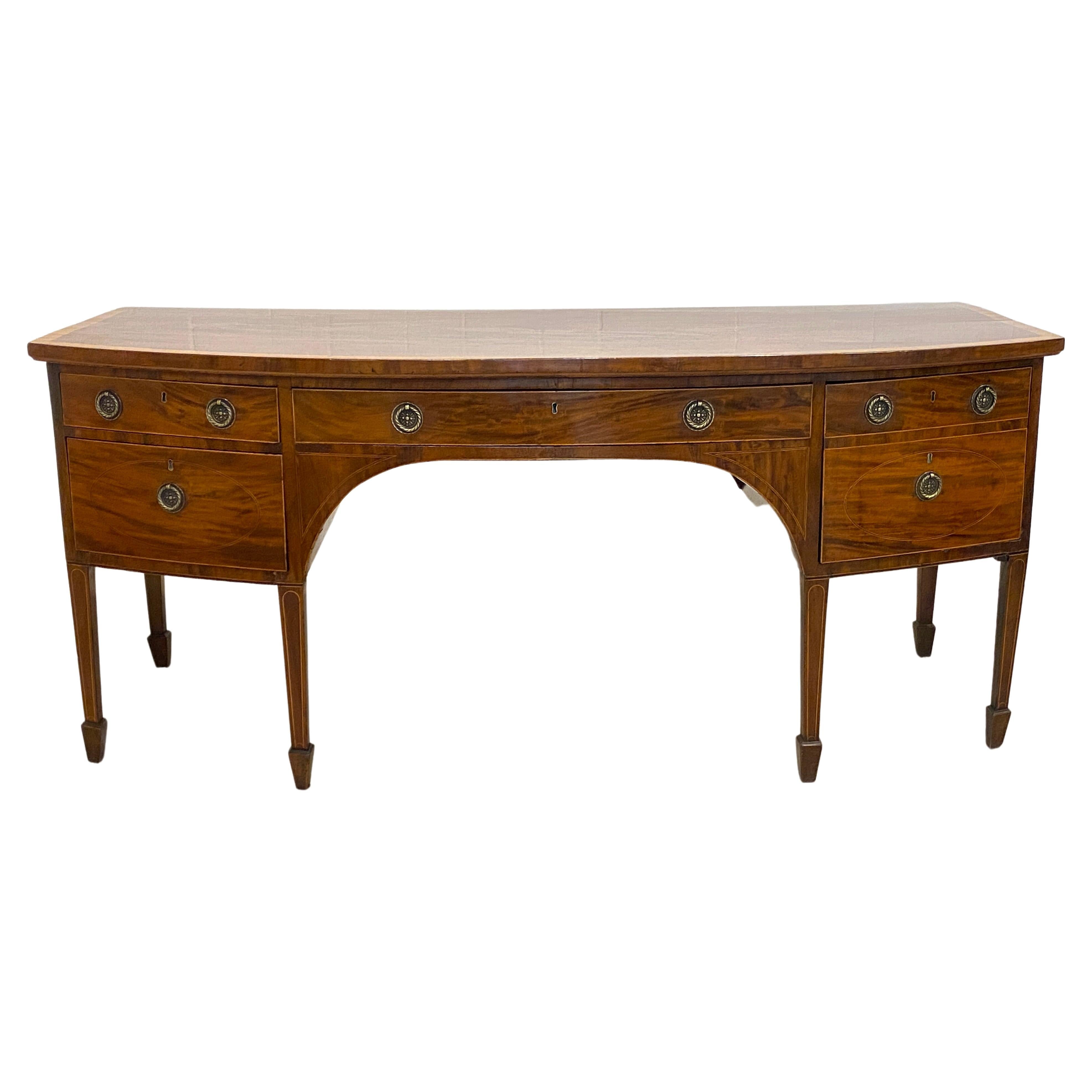 A beautiful 18th century style banded top mahogany English, Georgian sideboard. 
This sideboard is an antique of large proportions, with the traditional graceful lines of a bowed front classic.  Lots of original patina gives this gem the character