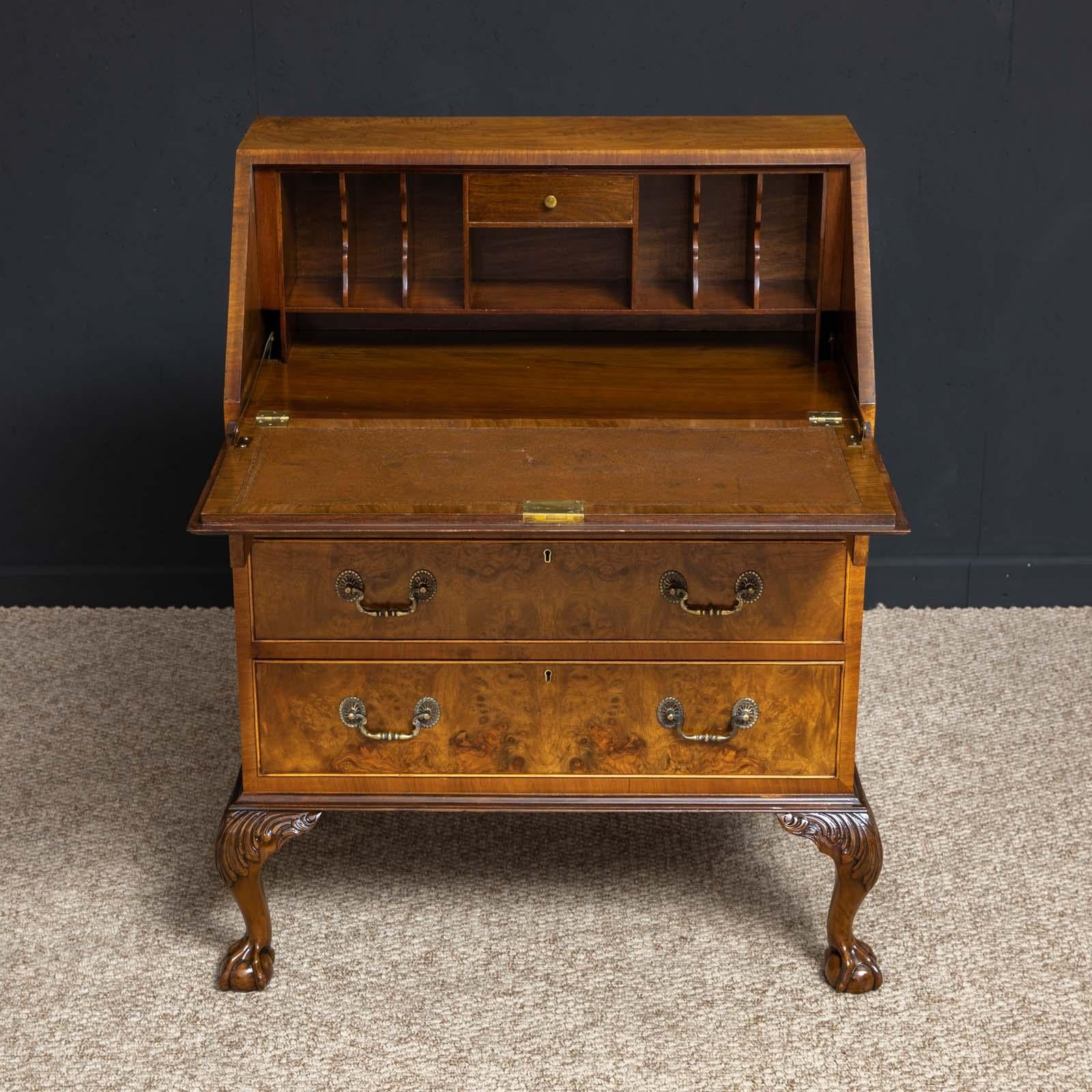 A good walnut bureau in the mid-18th century style. Sat on bold cabriole legs with acanthus carvings to the shoulders and finished on ball and claw feet. The burr walnut faced drawers have top quality cast brass swan neck handles and working locks