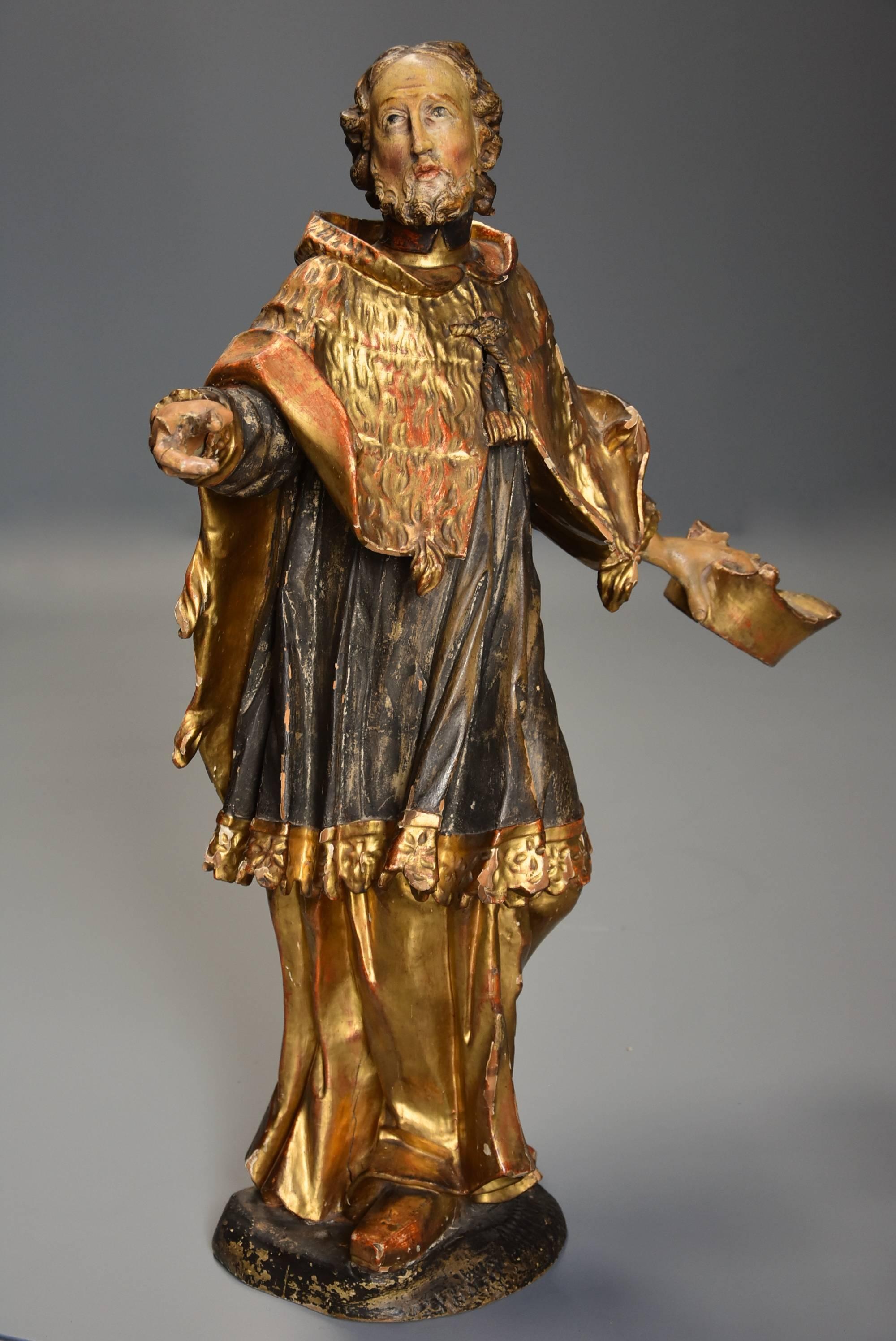 A superbly carved and highly decorative 18th century (circa 1760) Continental polychrome and gilt figure of Saint Peter.

This carved figure depicts St Peter standing in his gold and blue robes with textured gold cloak holding a hat, possibly his
