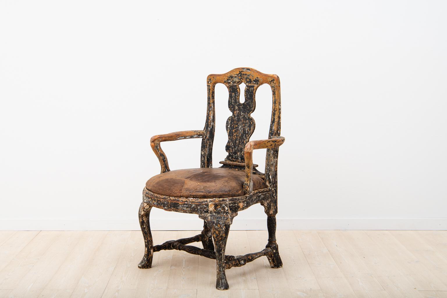 Swedish baroque armchair that’s been dry scraped to the black original paint. Seat with the old original dressing in leather. The leather has traces of older repairs and some wear. For occasional use it would work well. But in instance of daily use