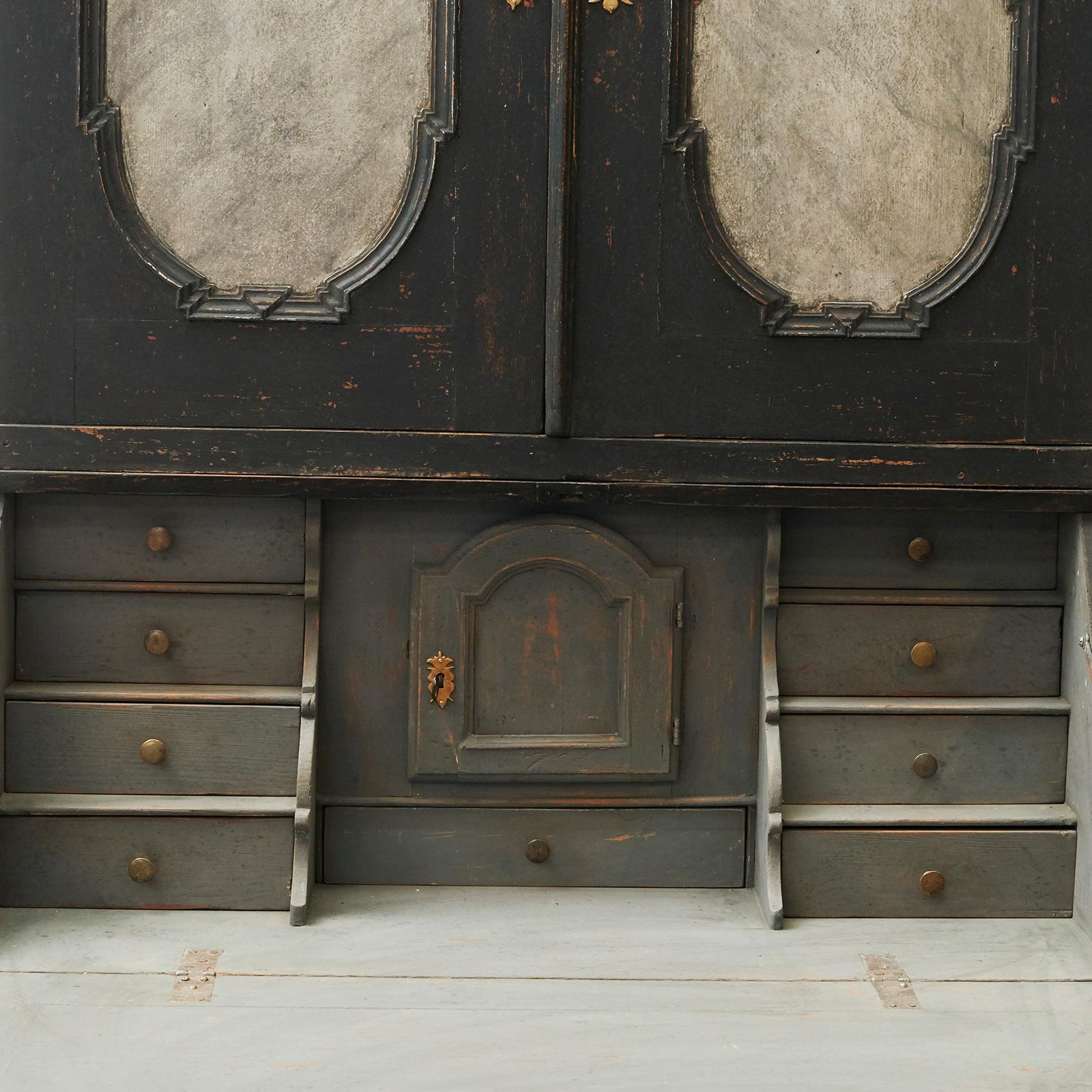 Baroque bureau, Sweden, circa 1750. Black-painted pine with gray-lined fillings. Behind the writing flap are numerous drawers in deep, grey color. A powerful and distinctive bureau (in 2 parts).