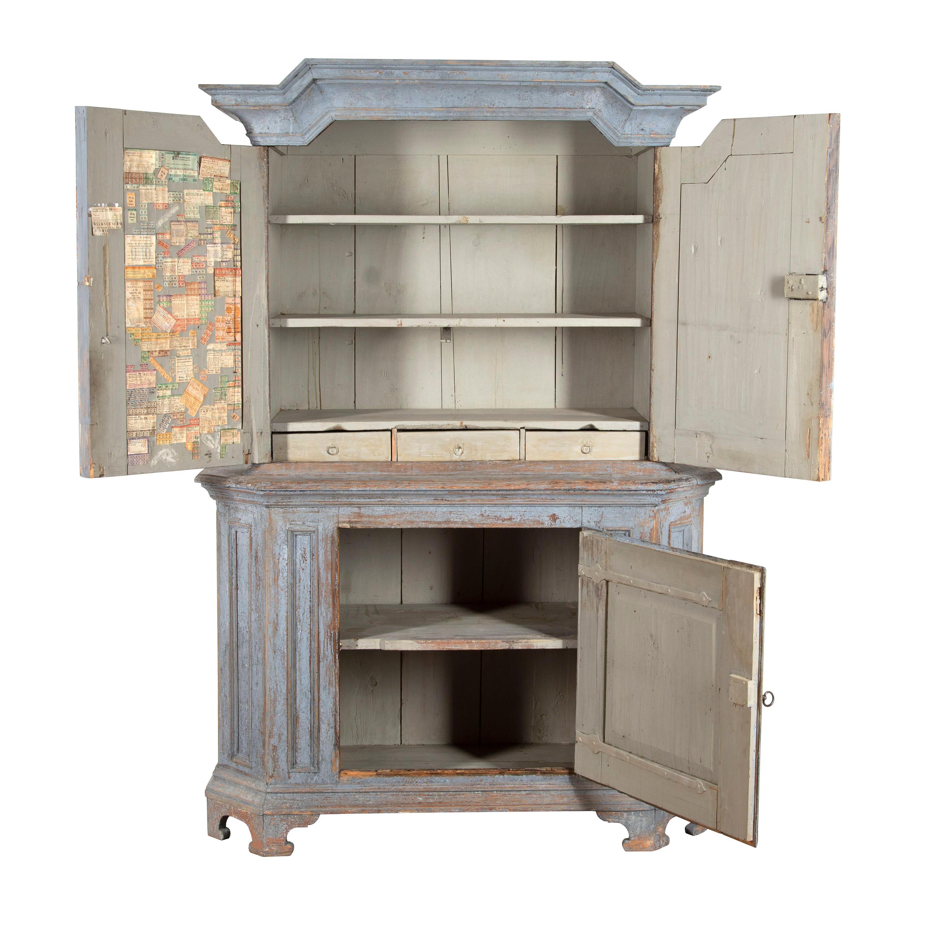 Swedish Baroque cabinet from the province of Bergsalgen.
This charming cabinet comprises of two sections, the top being slimmer than the bottom. The top section offers two panelled and decoratively painted doors with storage inside. The bottom