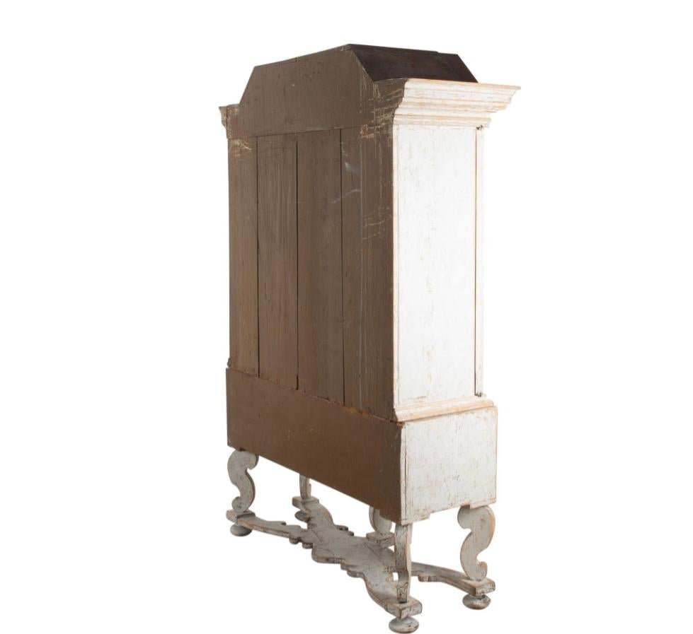 Armadio barocco svedese del XVIII secolo.
Con un frontone decorativo intagliato che si trova sotto due ante, che si aprono su uno scaffale. 
È stato ridipinto in grigio tenue.