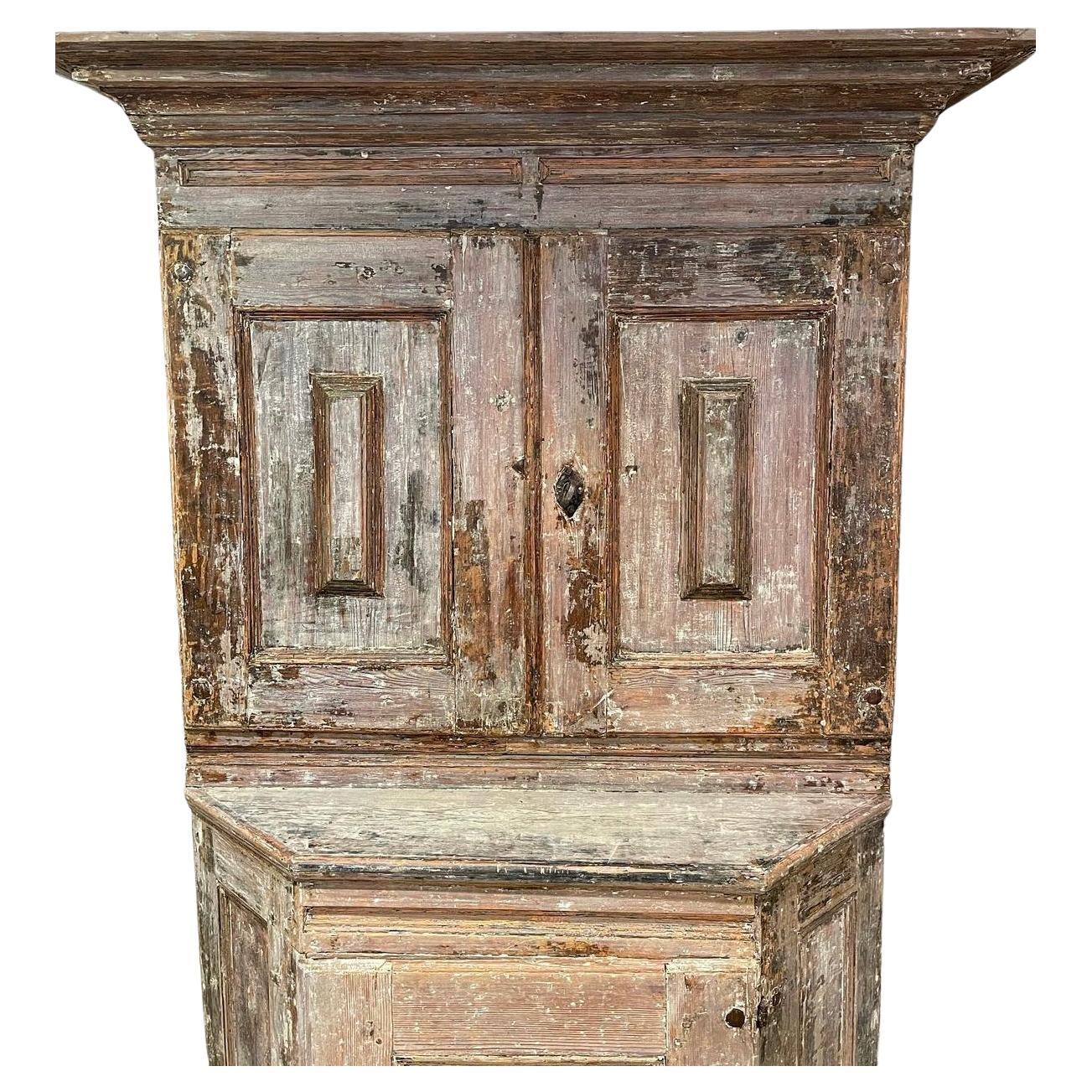 Stunning 18th century baroque Swedish cabinet. This amazing piece has been dry scrapped down to showcase traces of the original paint. Lots of neutral tones run through out this unique piece. Two doors feature shelves behind each cupboard which