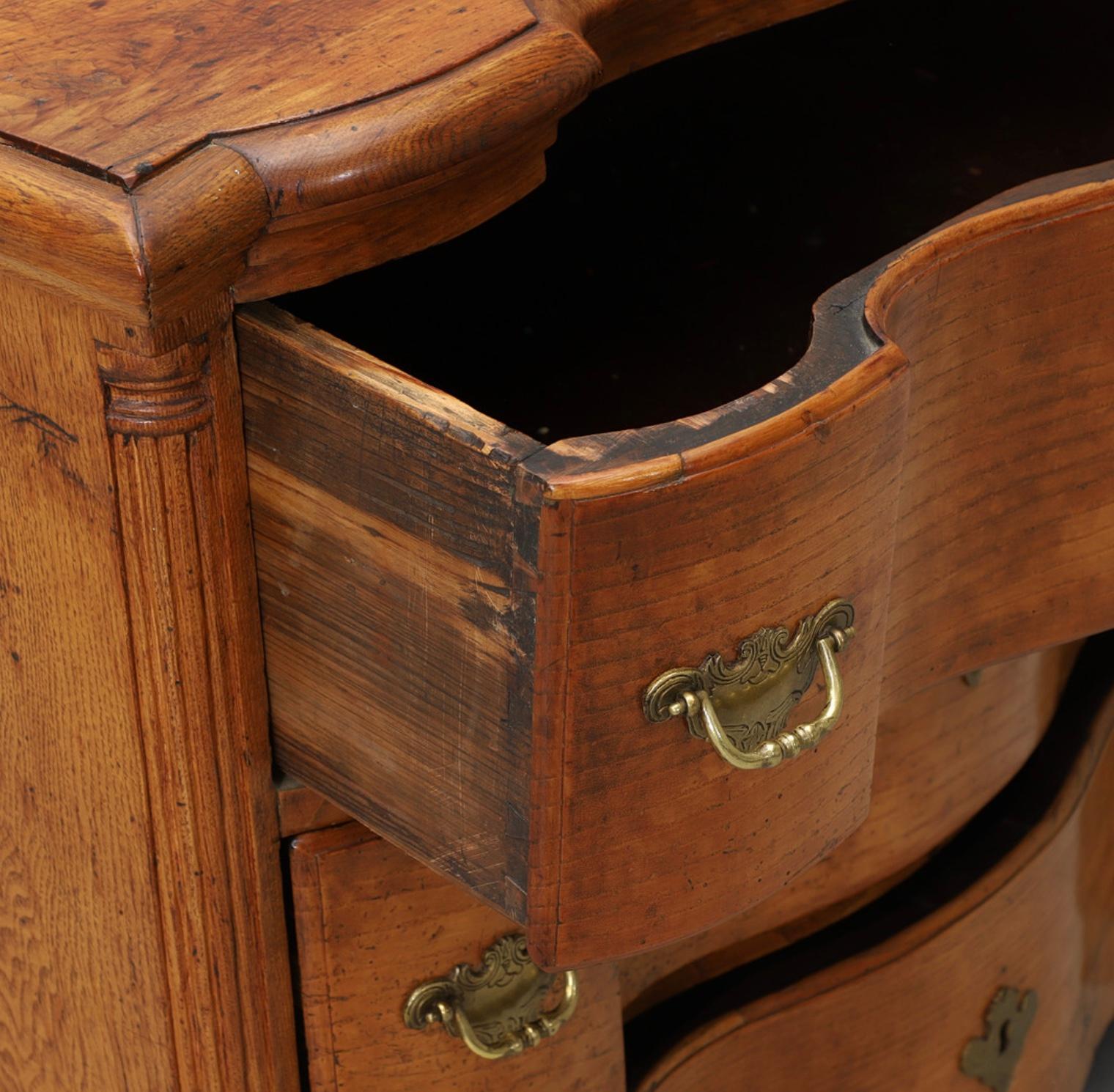 A handsome mid C18th swedish curved front commode in baroque style in a lovely warm mid brown elm.
Its three useful deep curved front drawers are framed by decorative gadrooned pilaster detail.
With key, later hardware and minor wear and tare