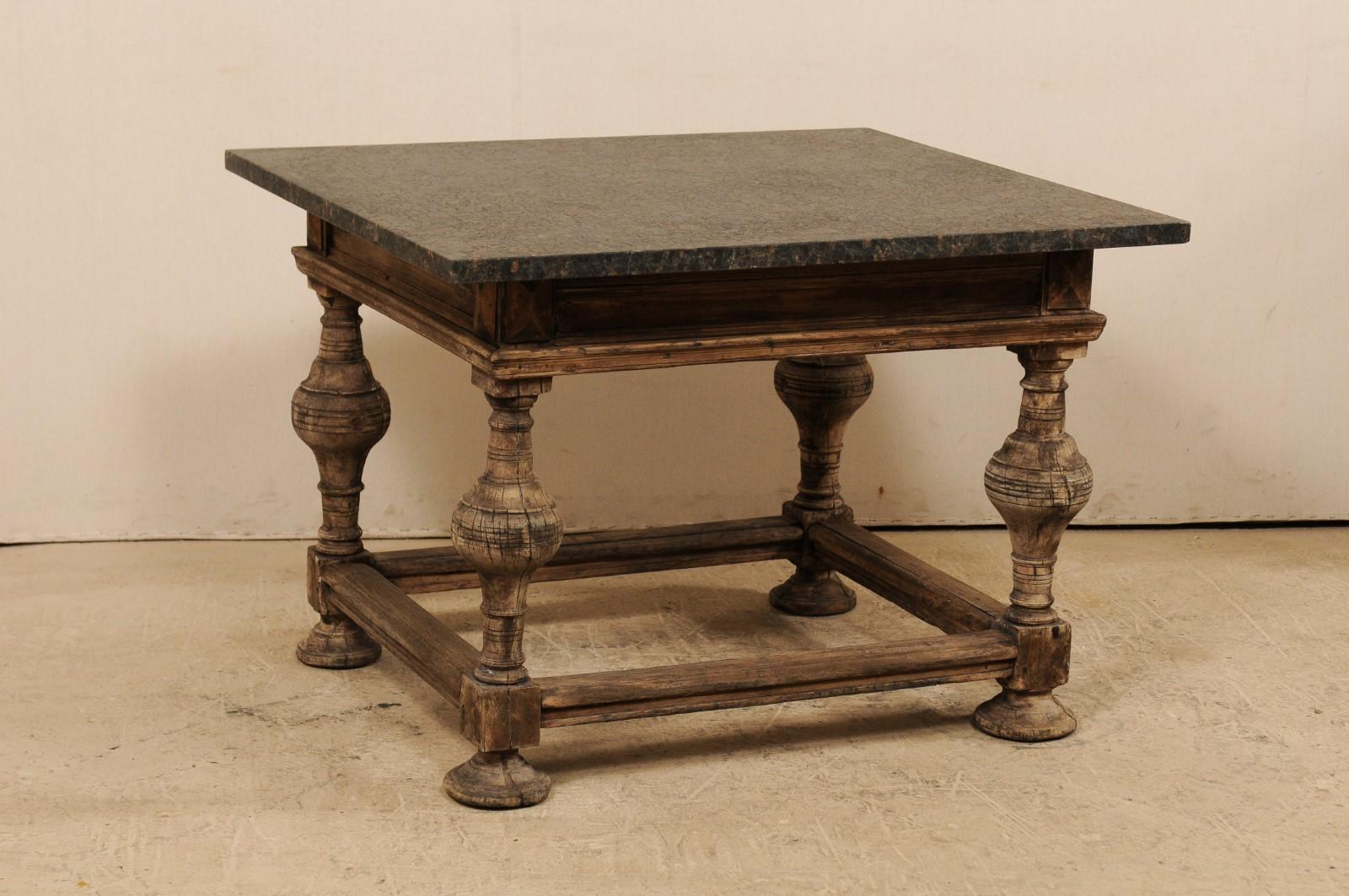 A Swedish Baroque table from the 18th century with newer honed granite top. This Baroque occasional table from Sweden features a honed marble top which rests upon a robust wood frame having a nicely molded skirt, and legs, one at each corner, carved