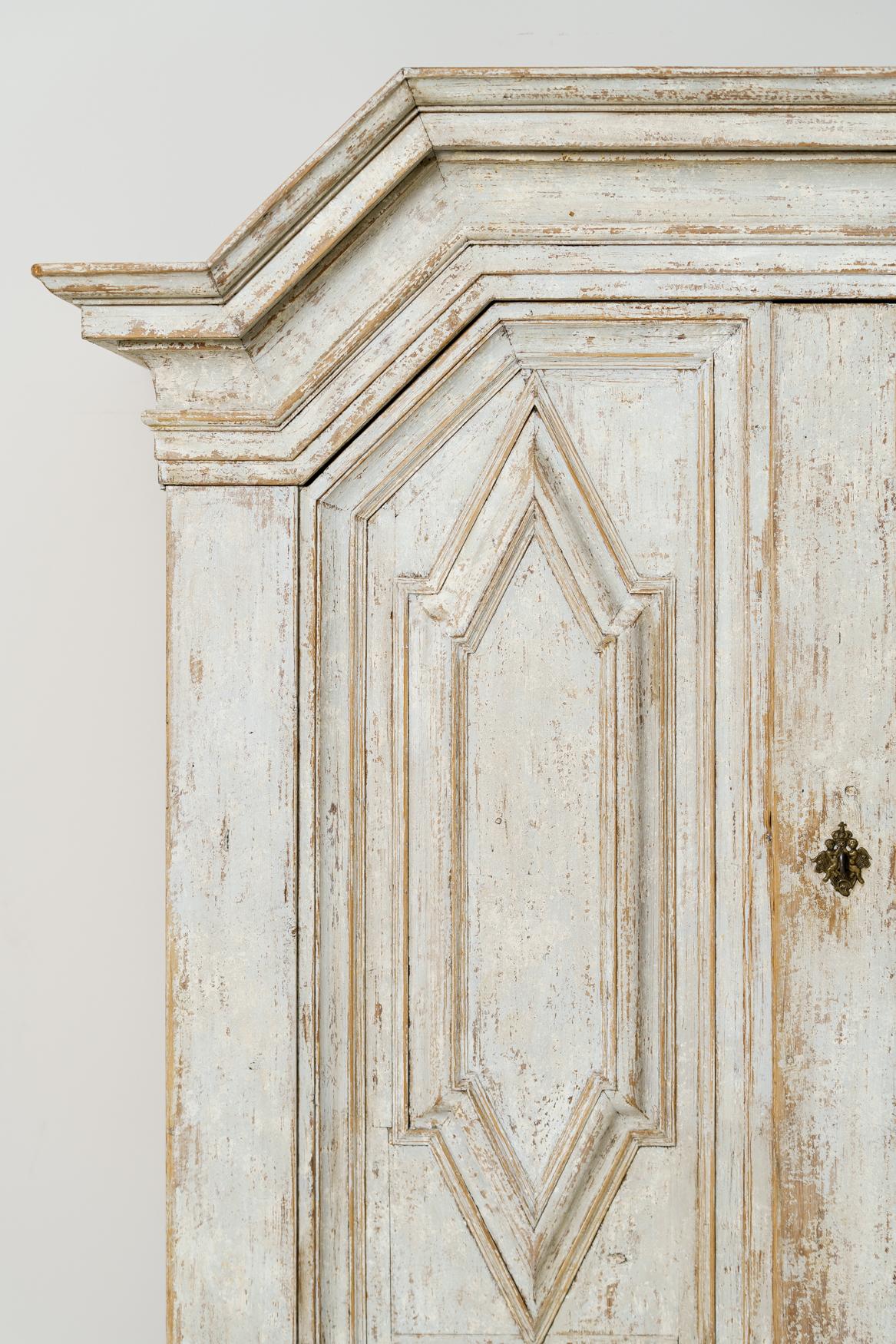 An important and richly carved Swedish armoire or linen press cabinet from the Baroque period with handsome ball feet, circa 1750. The large doors sit above a single drawer and open to reveal three adjustable, internal shelves. This is a rare piece