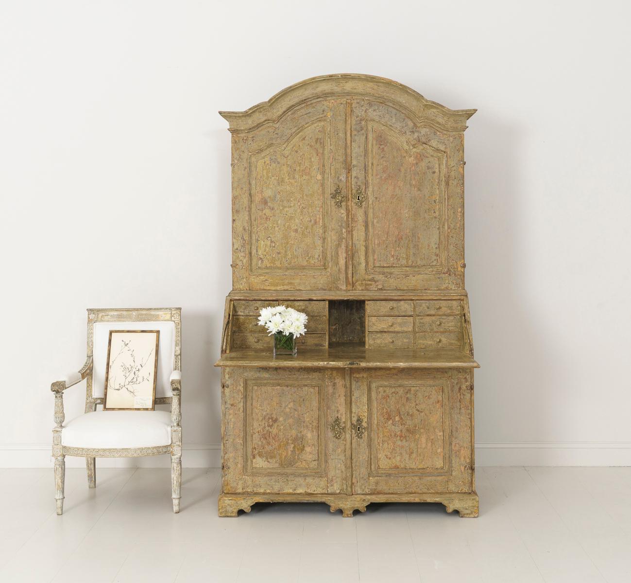 A Swedish Baroque period slant-front secretary from the 18th century in two parts with arched cornice and shaped apron. Brass hardware and original locks, circa 1770. The paint has been hand-scraped down to the original paint surface. The