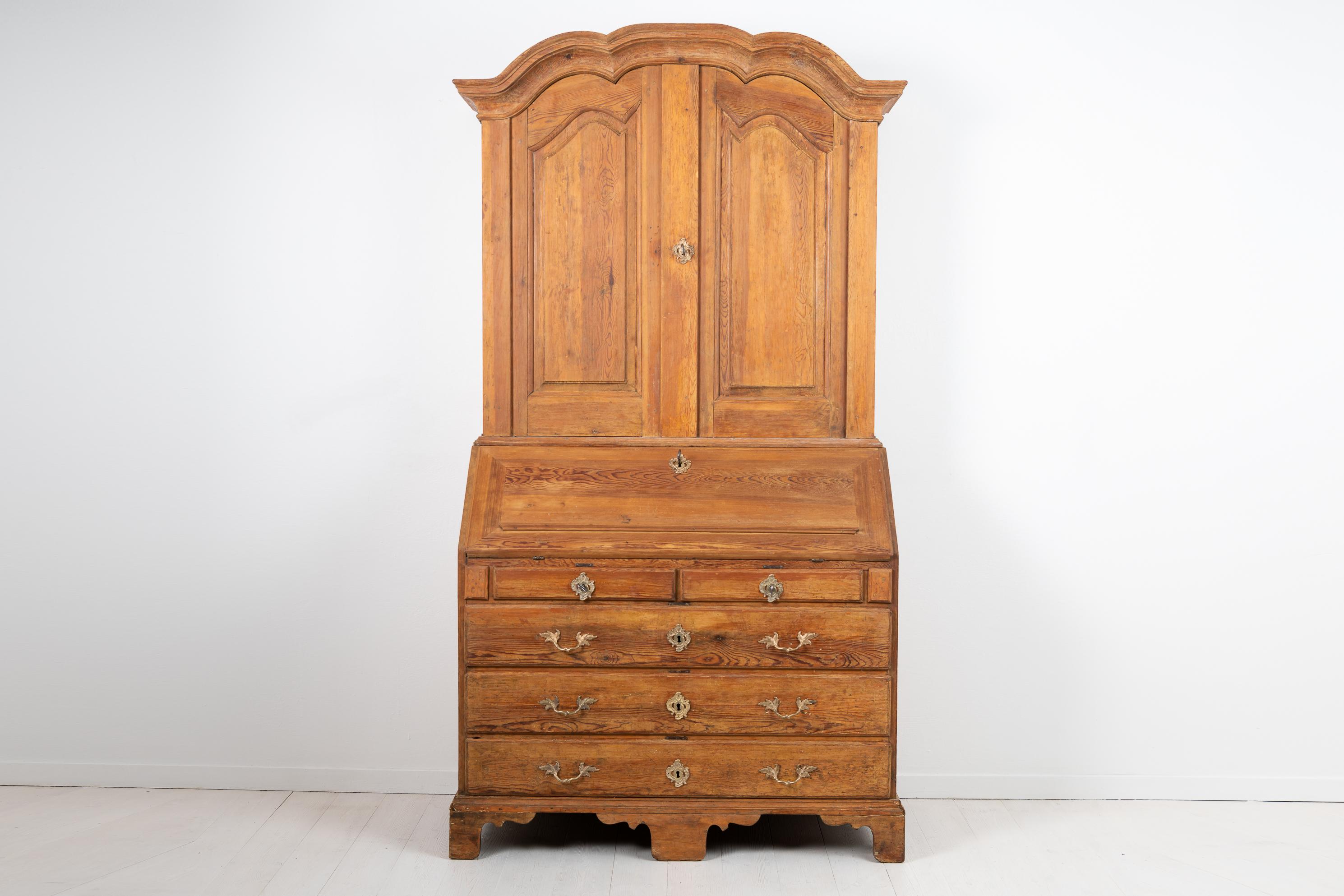 Elegant Swedish bureau cabinet most likely made around Stockholm during the transition period between baroque and rococo. The cabinet is in two parts and the exterior is unpainted pine. The interior has the original blue paint with multiple small