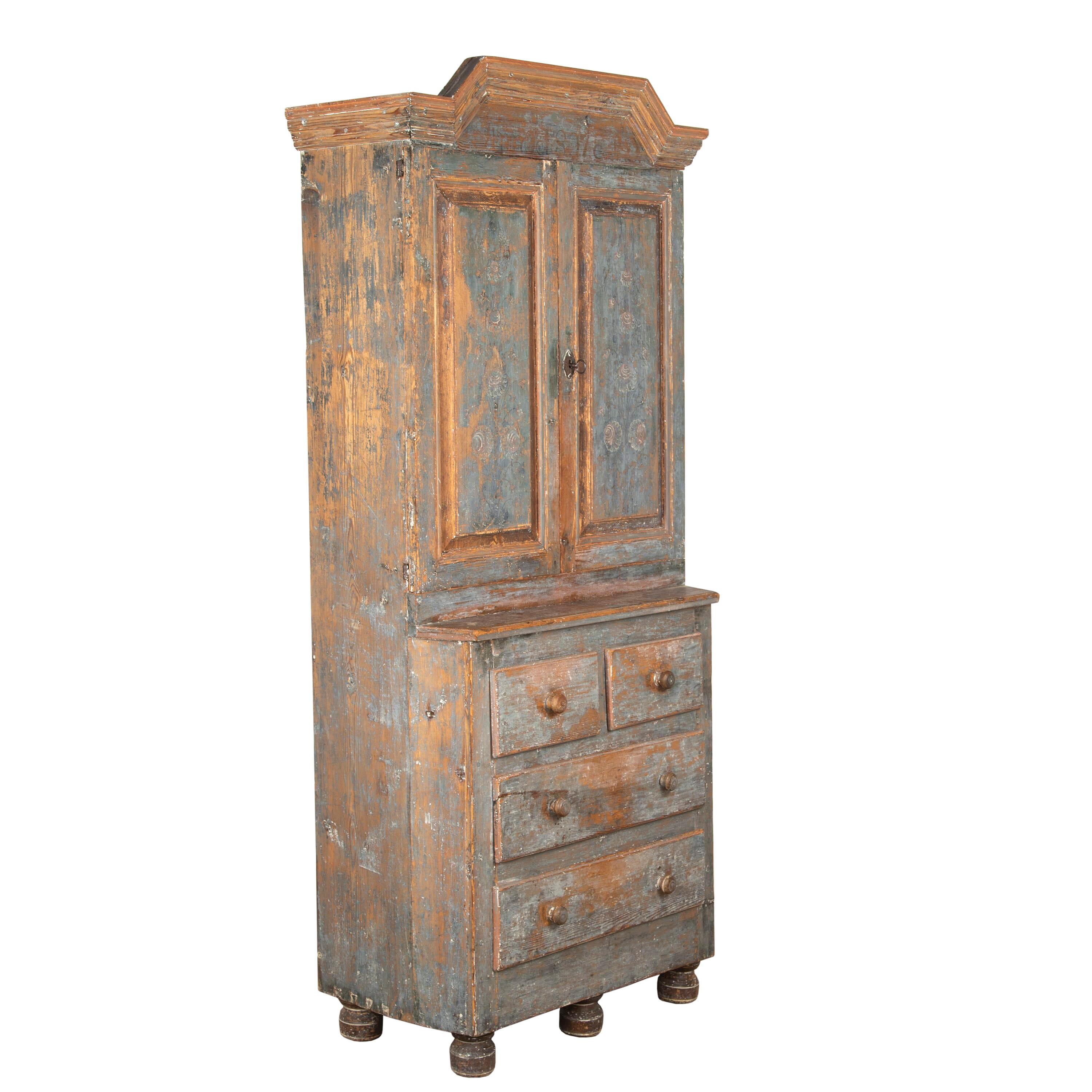 Exceptional Swedish 18th Century cabinet in its untouched and original paintwork.
This superb piece features a wonderfully carved pediment that sits above two beautiful doors that are etched with floral details throughout. The two doors open to