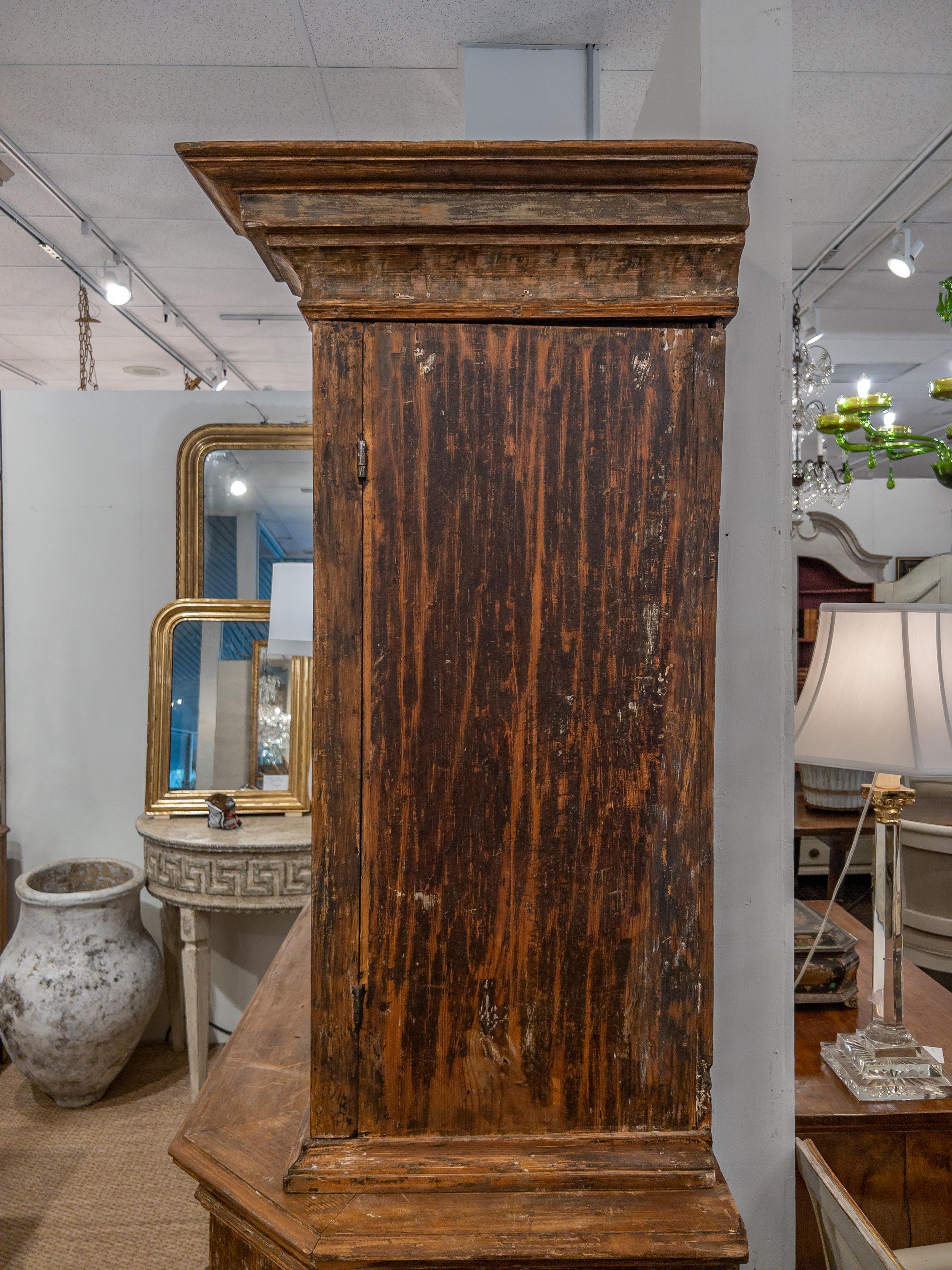 Swedish two part wood cabinet from the 18th century with original paint and hardware. The top section features two doors with decorative carved detailing, opening to shelving and six drawers. Whilst below two further doors with further detailing