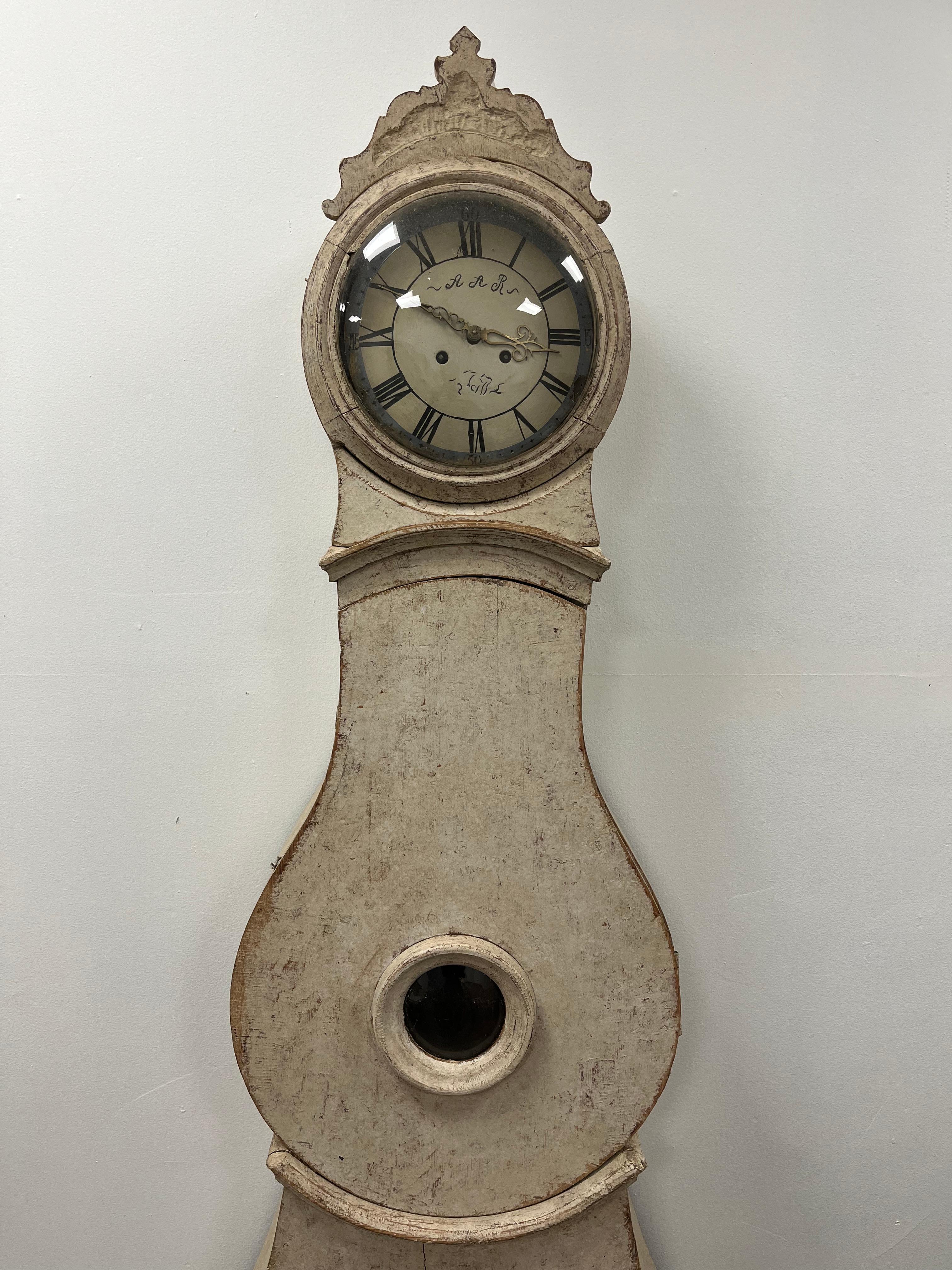 Une horloge suédoise unique en son genre, repeinte en couleur crème. L'horloge est vendue en tant que pièce décorative, sans garantie mécanique. Les poids (mais pas le pendule ni la clé) sont inclus.
