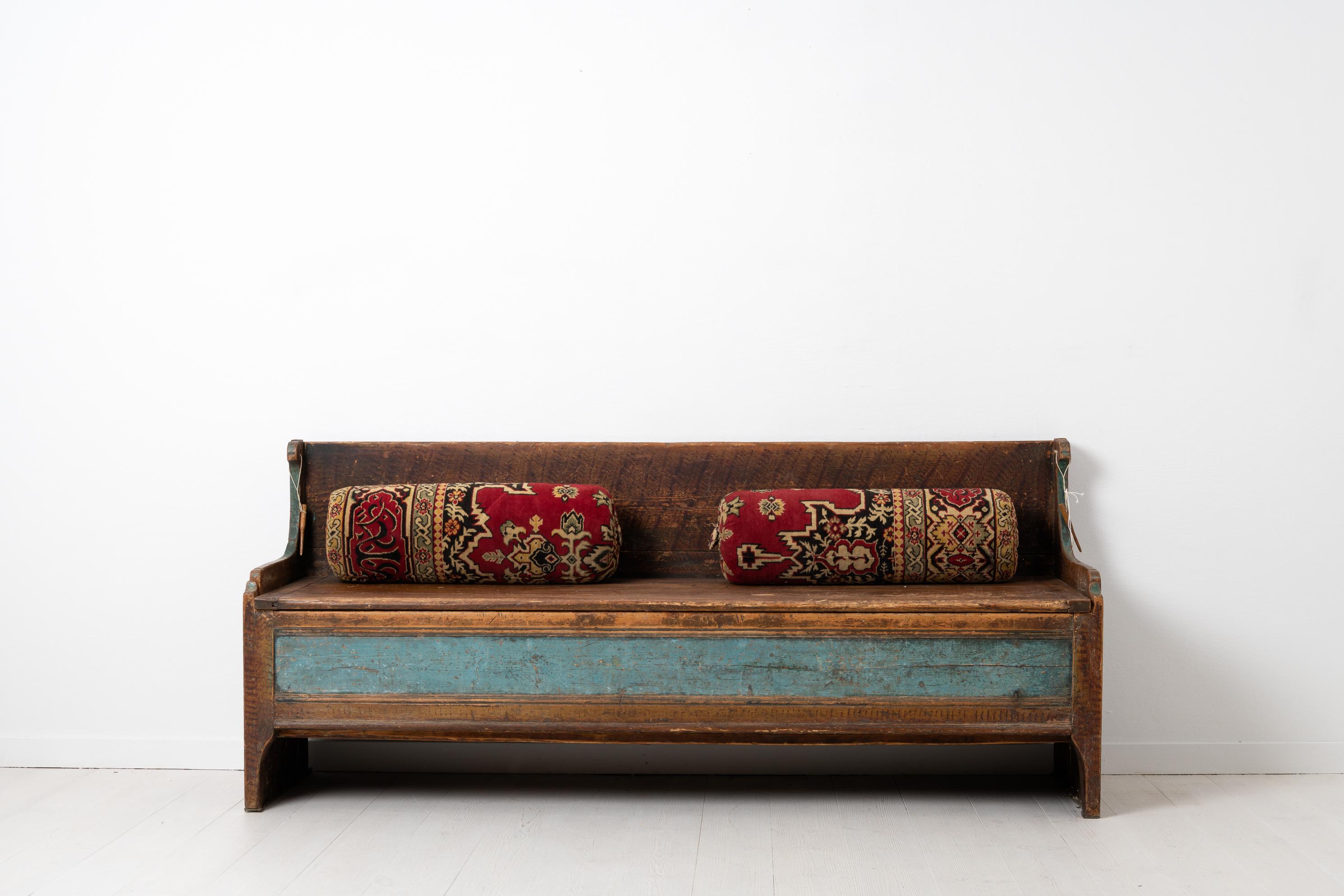 Swedish late 1700s country bench made in Swedish pine. The bench, a so called fållbänk, is folk art and in untouched original condition. The bench have the original faux paint and painted blue panel at the front as well as a completely genuine