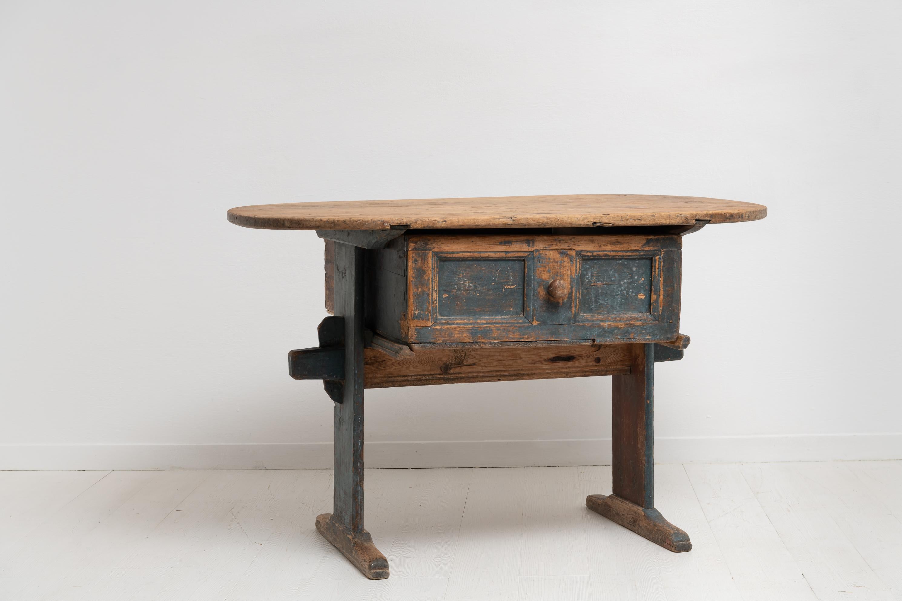 Folk Art country table from northern Sweden made in pine during the late 1700s. The charming table is an unusual country furniture in genuine untouched condition with original paint. Authentic wear after almost 250 years of use. Oval wood bare table