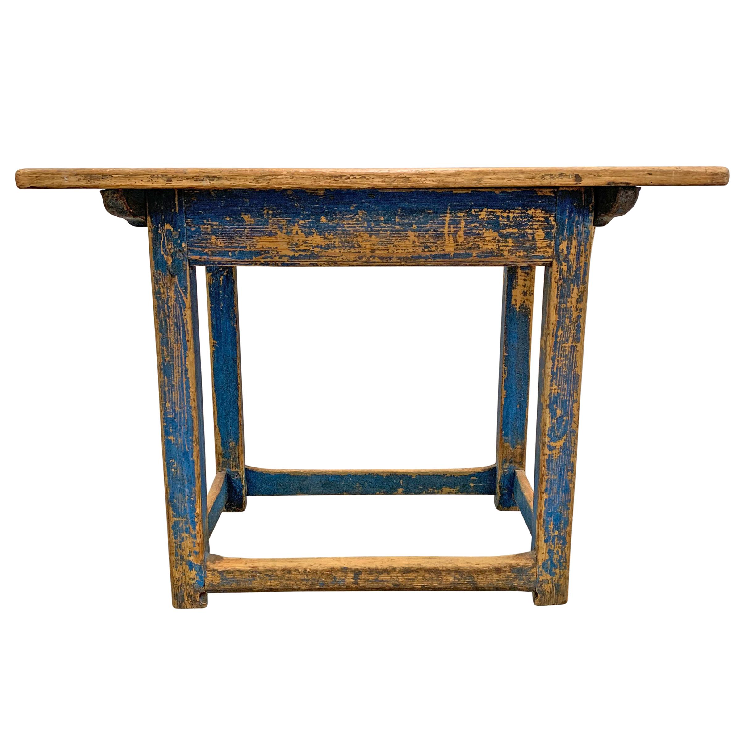 A gorgeous 18th century Swedish pine farm table with its original royal blue painted finish, and wonderfully worn stretchers showing centuries of use. The top is held to the base with wooden pegs.