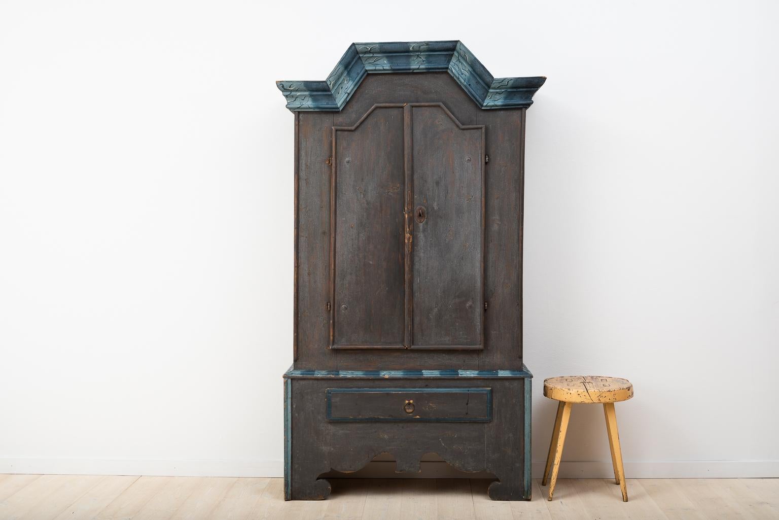Charming rare Folk Art cupboard from Jämtland. Manufactured late 1700s. The model was manufactured in an area called Haga which is why this type with the straight crown and raised middle is often called Haga cabinets. Original paint with marbled