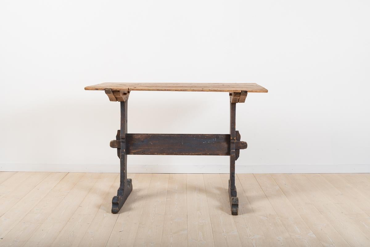 Smaller charming trestle table with unusually profiled leg frame with original blue paint. The tabletop has a chamfered edge and has never been painted. The tabletop has small and shallow marks and trances after 250 years of use - see pictures. The