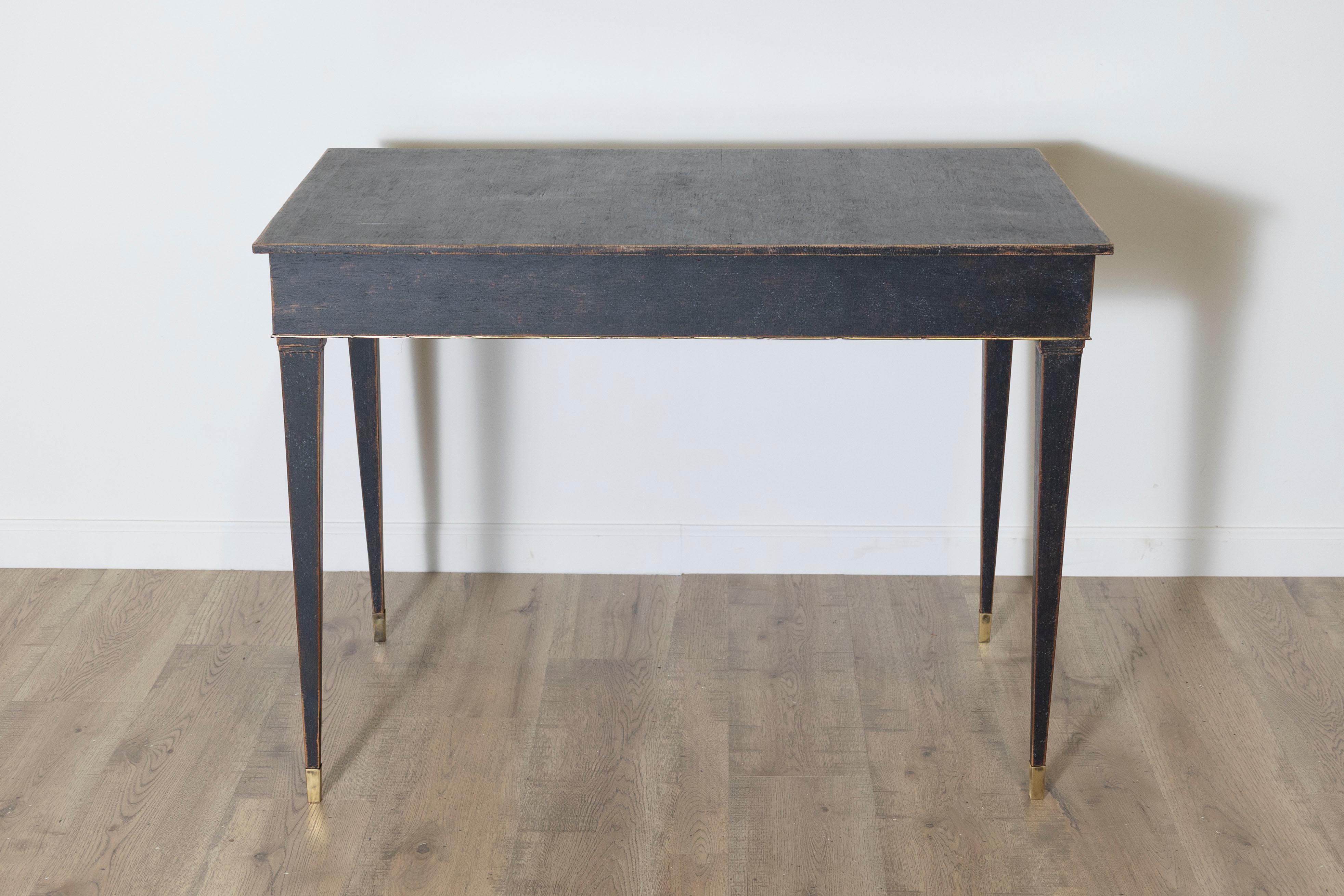 This elegant 18th-century Swedish game table, circa 1790, is a remarkable example of Gustavian design, blending neoclassical sophistication with functional craftsmanship. Constructed from pine wood and painted in a striking black finish with subtle