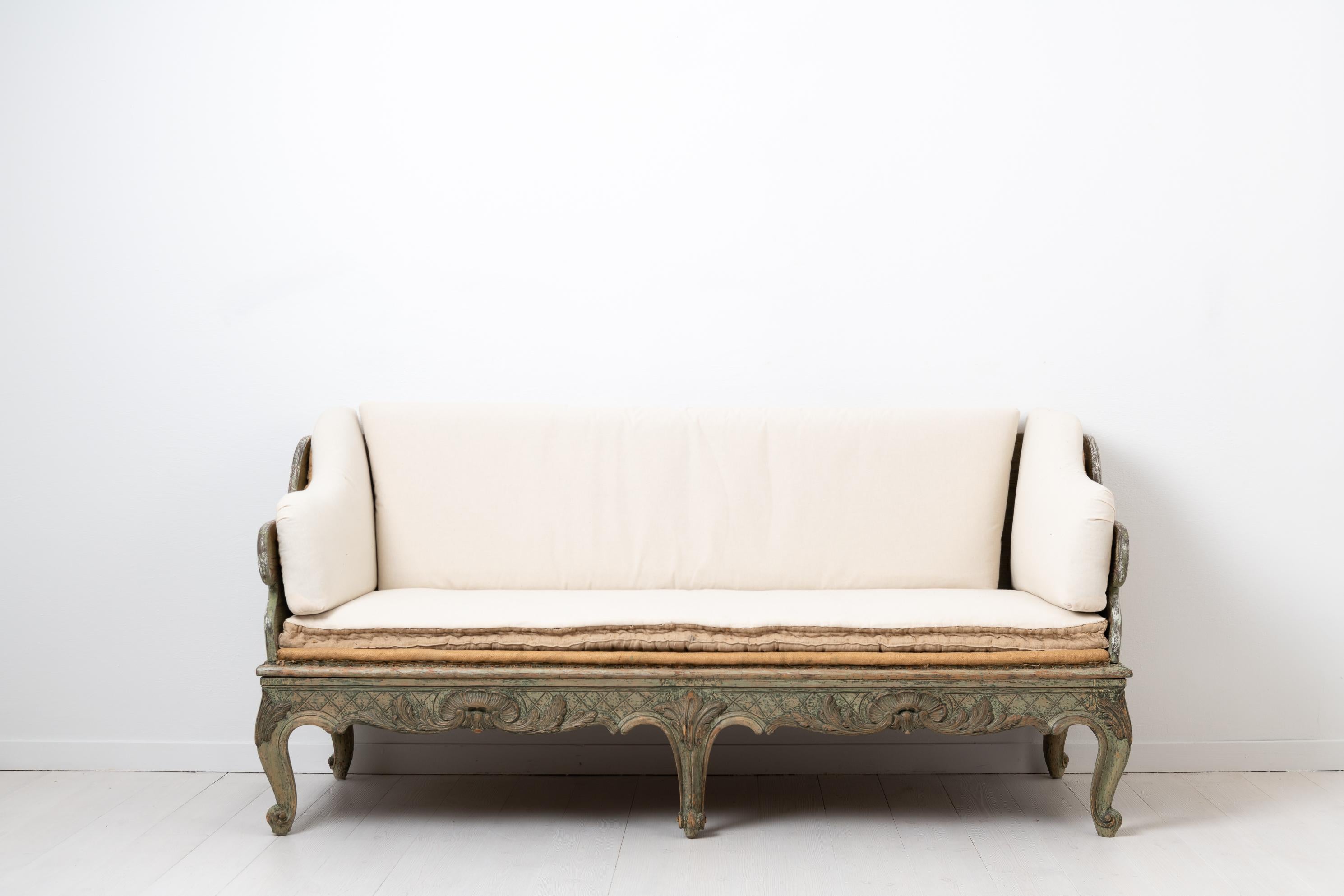 Rococo sofa made circa 1770 in Sweden. The sofa is hand scraped to original paint from 1770 with natural distress and authentic patina. Made in pine and richly decorated with hand carved wooden decorations in the shape of clam formations. This model