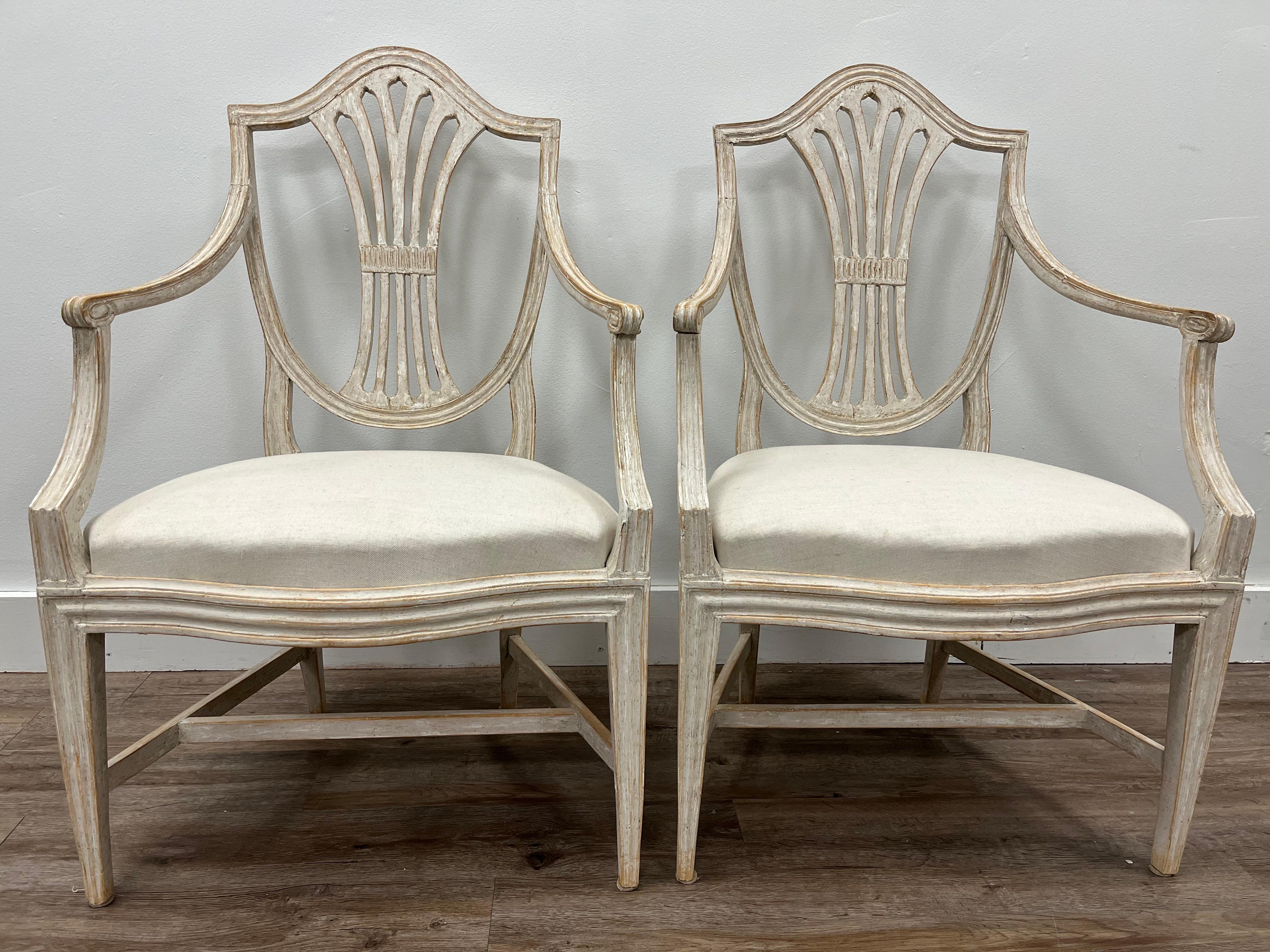 A stunning pair of Gustavian armchairs made in Stockholm and signed by Johan Erik Höglander (1758-1813). Arched shield back style with bow front seats. Frame - back, arms and base with detailed contours. One chair still retains its original