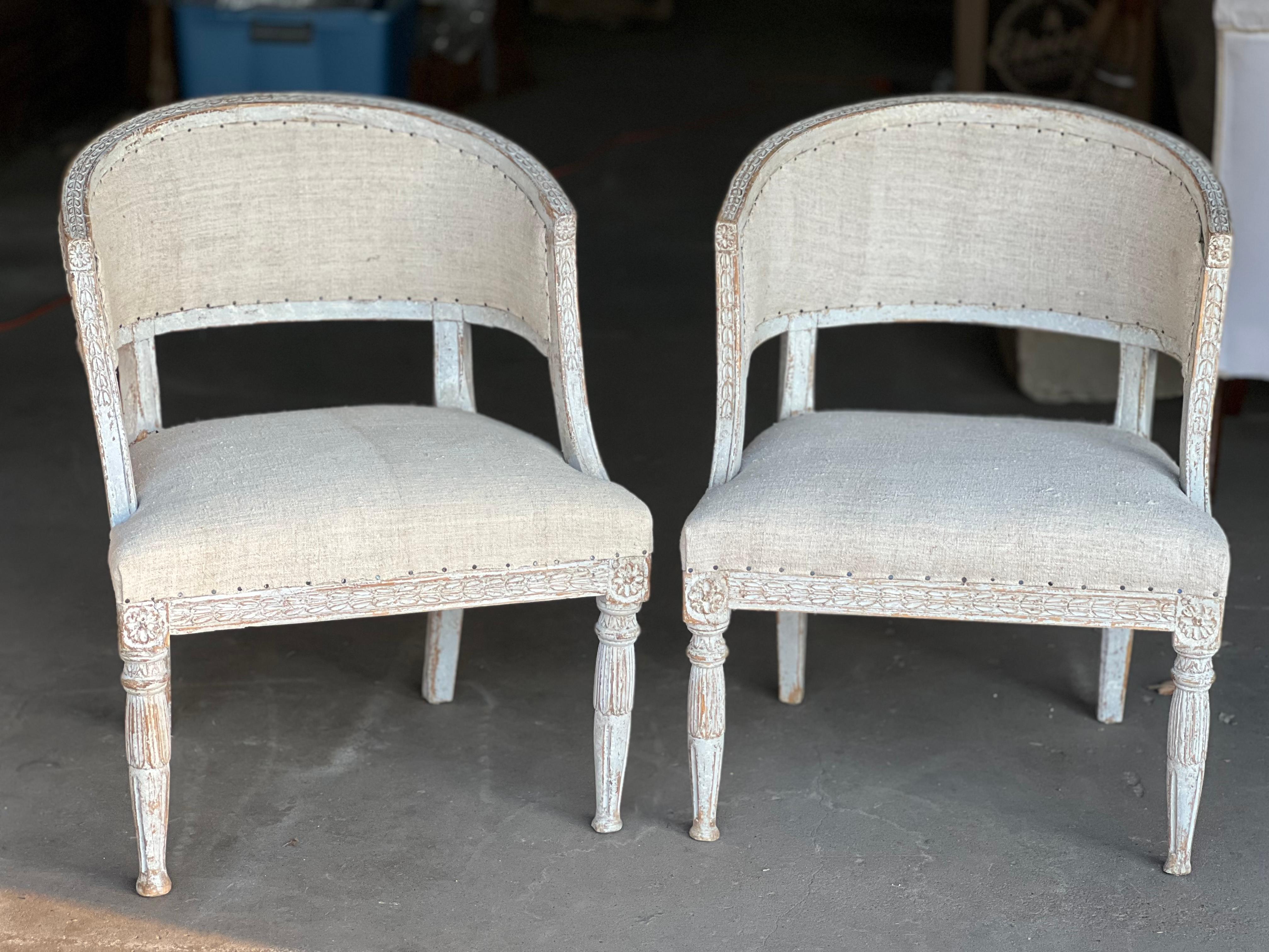 A gorgeous and unique pair of late 18th Century Swedish barrel backs from the Gustavian period that have been dry scrapped and then had a recent paint touch up with grays and white hues to the wooden details. Fine details include: rosette carvings