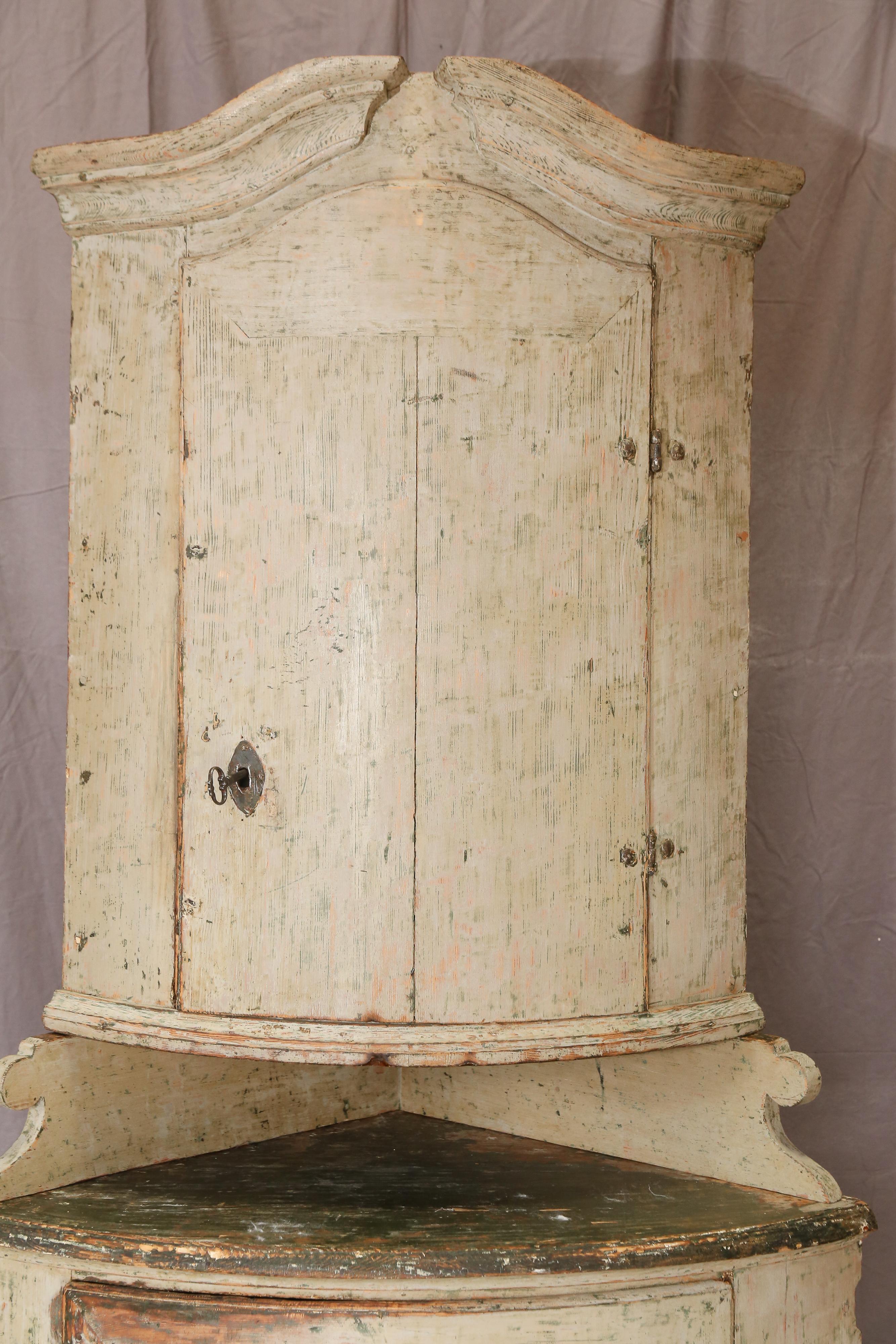 18th century Swedish Gustavian Corner deux corps. Original paint both on the outside and the inside. Inside is light blue. Outside is a muted grayish white. Charming piece! The top piece rests on a 90 degree angled carved spacer. Left side depth: