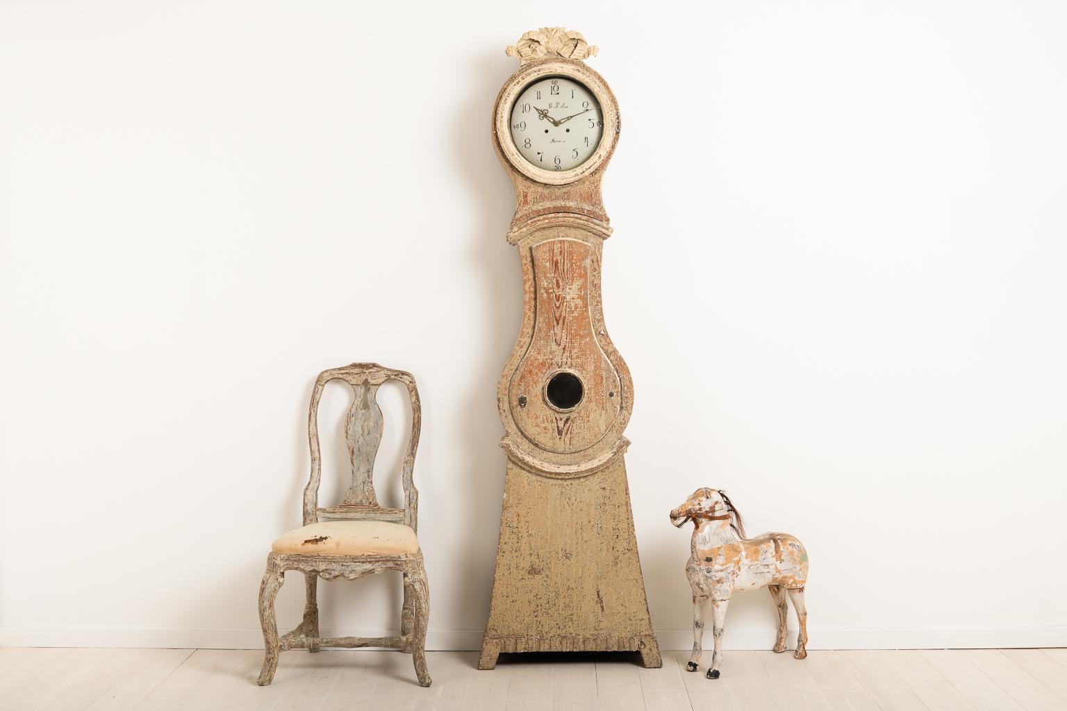 Swedish Gustavian long case clock made circa 1800. The clock is dry scarped to original paint. An unusual detail is the lock on the door which is also in fully working condition. Old original glass in the ring and on the door. Healthy and solid
