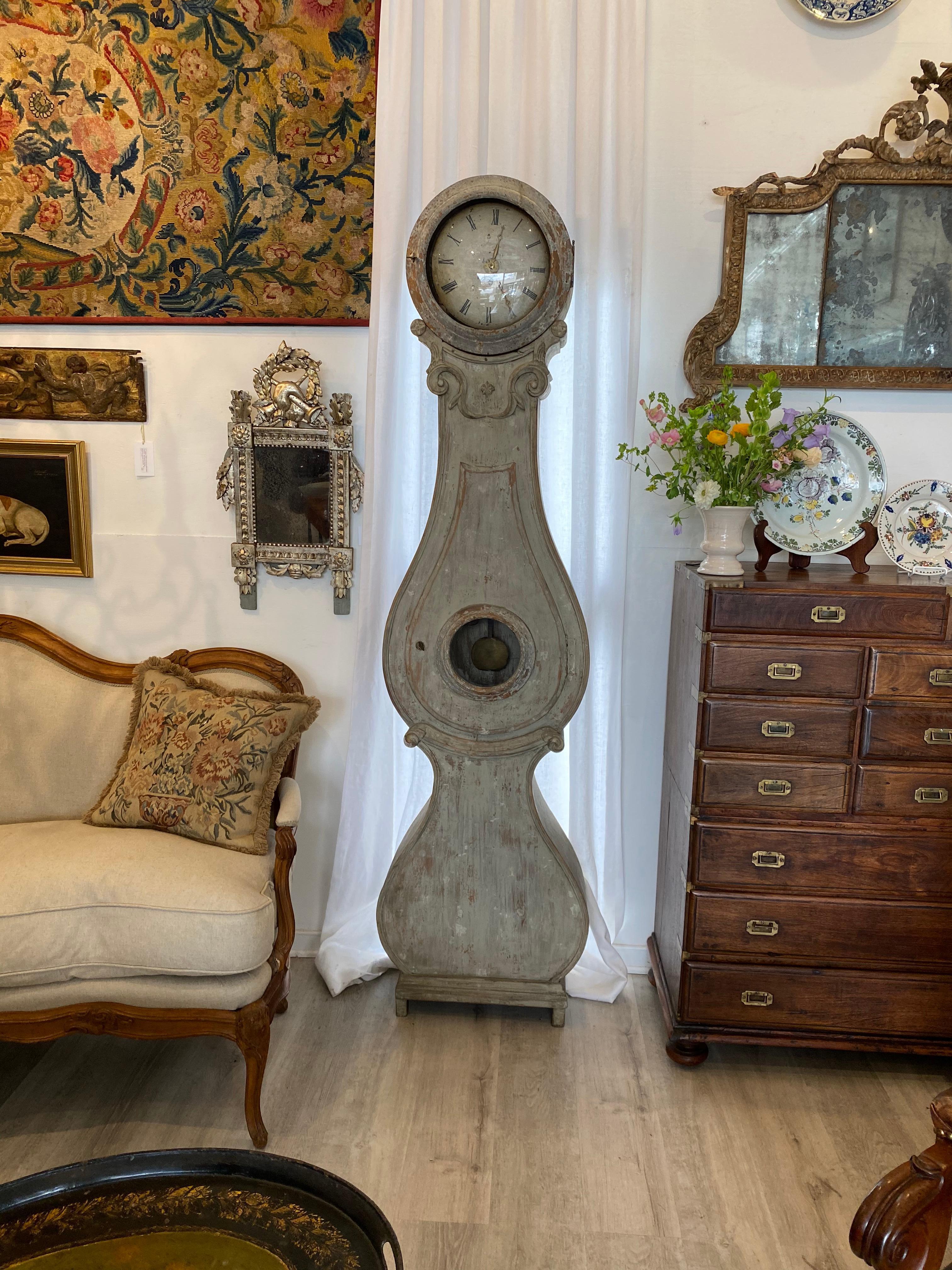 Rare, authentic 18th century Swedish Mora clock, circa 1790. with very graceful serpentine shape and an arresting stance, circular hood with original enamel clock face over scrolling and flared base over charming ogee feet. The face includes a quite