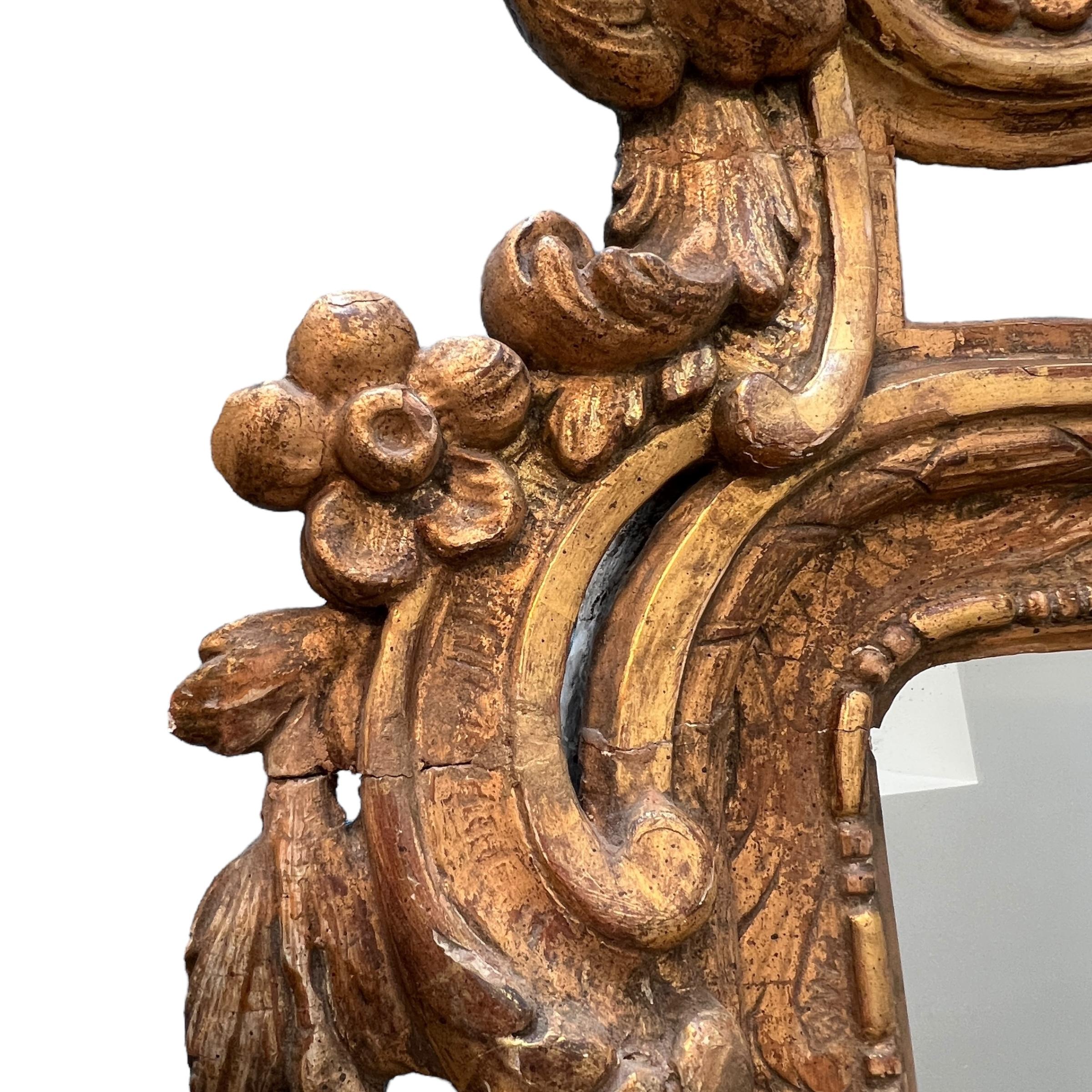 Questo specchio neoclassico svedese del XVIII secolo presenta una raffinata cornice in legno dorato dalle linee pulite e intagli con ghirlande, fiocchi e festoni, oltre a incarnare l'elegante sobrietà e simmetria caratteristica del design gustaviano.