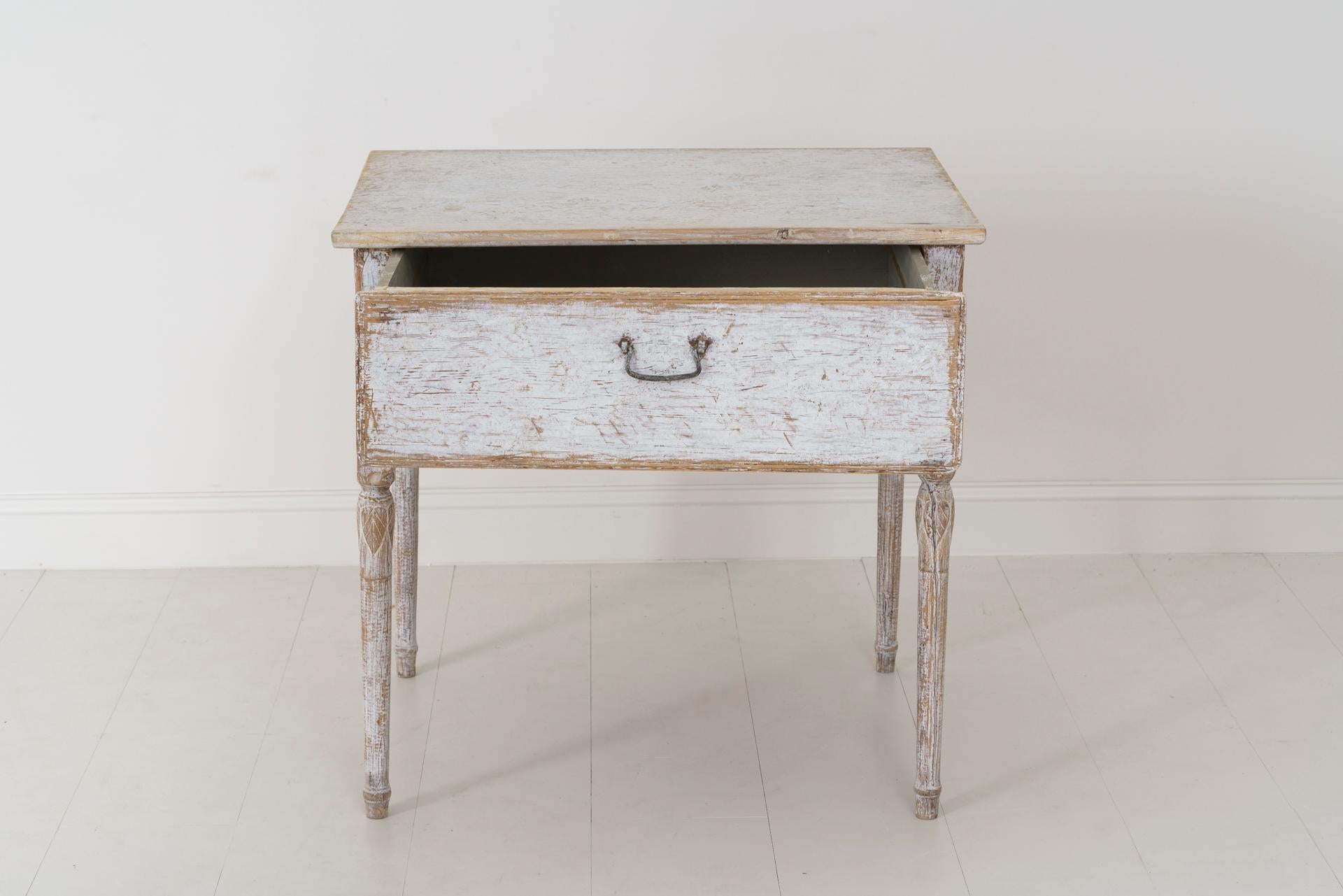 A charming 18th century Swedish center table from the Gustavian period. This rustic allmoge (country folk) table is finished on all four sides, has a deep drawer, elegant tapering legs, and leaf motif moldings.