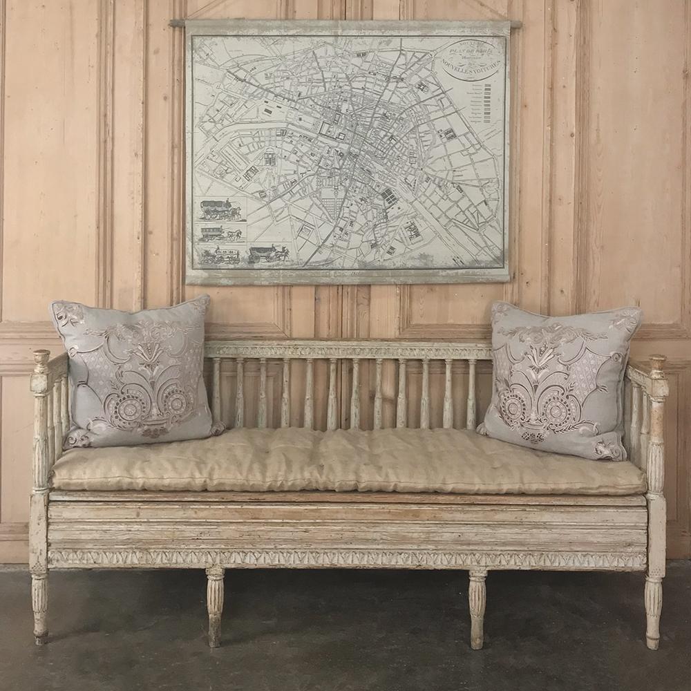 18th century Swedish Gustavian period daybed - hall bench circa 1790 features tailored, neoclassical lines that are definitive of the era, with slat backs surrounding the seating area, and charming rustic carved motifs around the top of the gallery