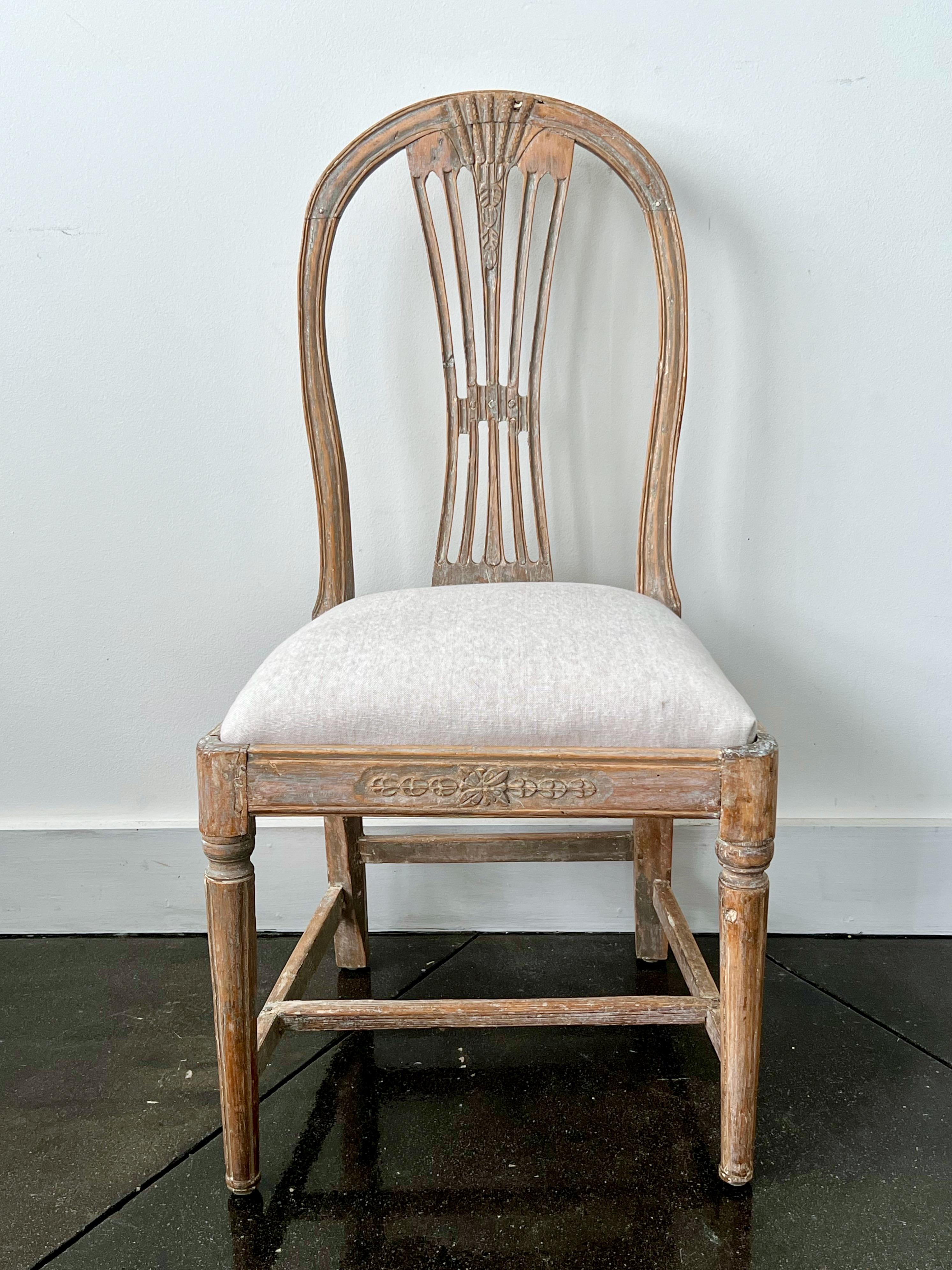 18th century Swedish Gustavian period side chair hand-scraped to its most original paint, with oval back, pierced slats and carved wheat sheaf, cross stretcher, and slip seat cover in linen. 
NOTE:
We have other 18th century period single chair very